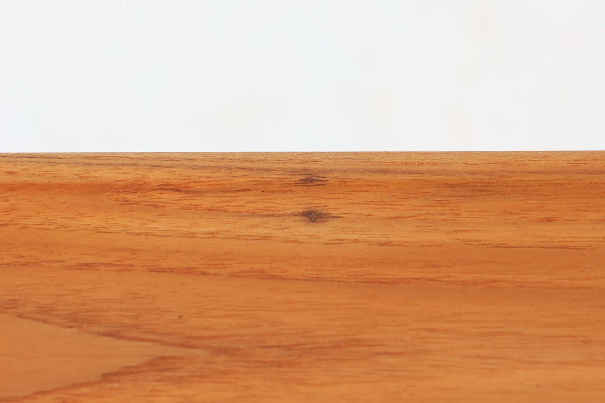 北欧より買い付けた、Hans J. WegnerによるAT10です。天板にはチーク無垢材が使われ、脚部にはオーク無垢材が採用されています。経年変化した籐の棚が特徴的で、温かみのある雰囲気を醸し出します。幅160cmというサイズ感は、3Pソファの前面に並べて使用すると、程良い距離感を保ちながら使いやすく、空間全体のバランスを整えます。縁が削り出されて丸みを帯びたデザインは、AT10の特徴であり、その独特の魅力が感じられます。