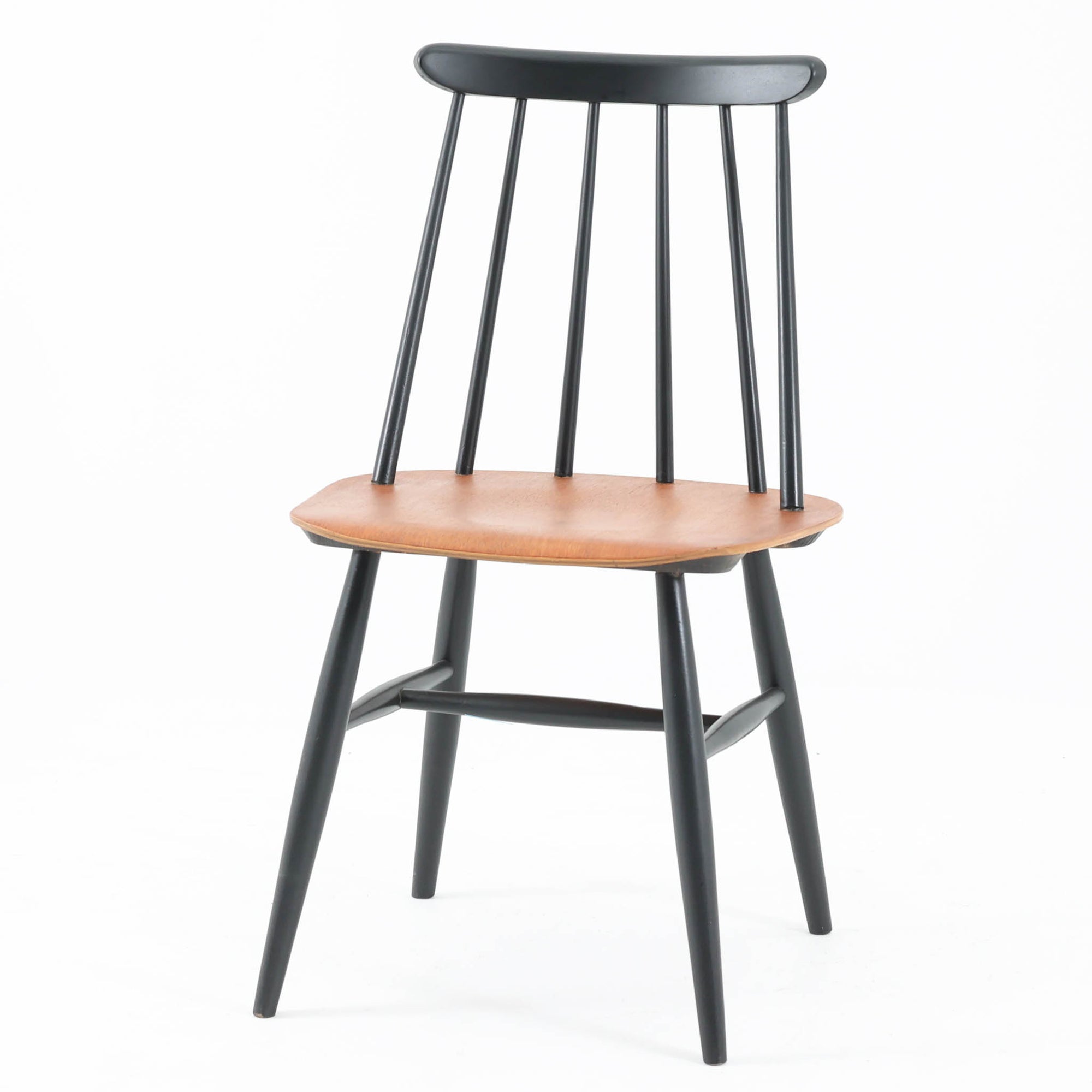 Ilmari Tapiovaaraがデザインし、Edsby Verkenが製作した「Fanett」ダイニングチェアです。チーク材の座面とブラック塗装のスピンドルが美しいコントラストを生み出し、軽やかで洗練されたフォルムが空間を引き締めます。背もたれに配された6本のスポークはビンテージモデルの特徴で、このチェアならではの印象的なディテール。背もたれから脚部へと流れる細身のラインは、北欧デザインならではの機能美と職人技を感じさせる佇まいです。食卓用としてはもちろん、デスクチェアやインテリアのアクセントとしても活躍し、時を経て深みを増した素材感がビンテージ家具ならではの魅力を引き立てる一脚です。