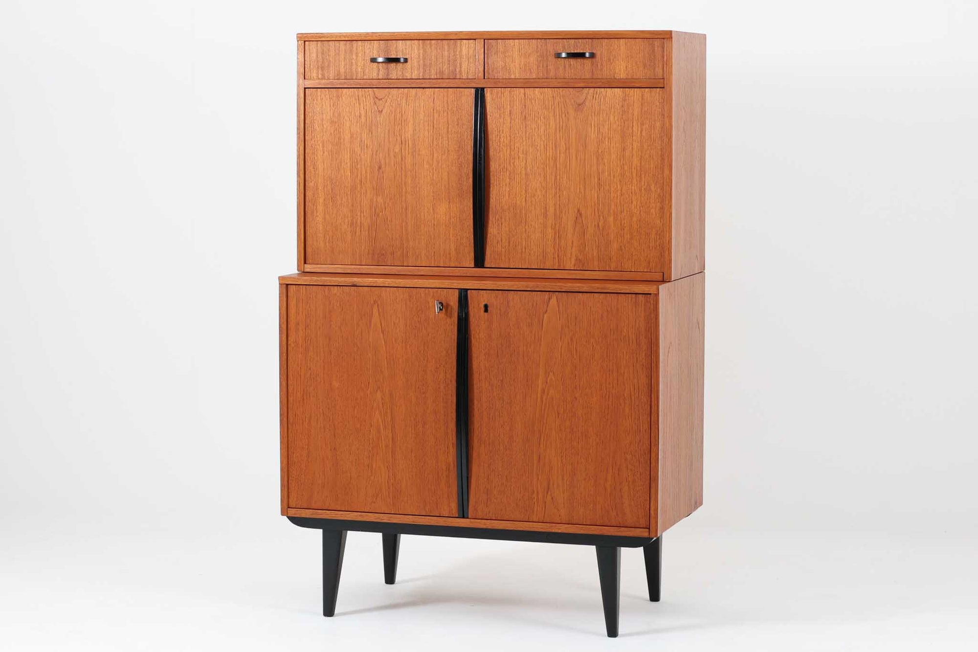 スウェーデン製の小ぶりなキャビネットです。このキャビネットは、鍵付きの収納スペースがあり、プライバシーを守りたいアイテムを保管できます。さらに、引き出しも付いており、小物や文房具などを整理するのに便利です。ブラックペイントの脚が取り付けられ、スタイリッシュな印象を与えてくれます。取手も同様にブラックペイントが施されており、手に心地よいグリップ感がございます。本体はチーク材で作られており、スウェーデン家具ならではのデザインです。