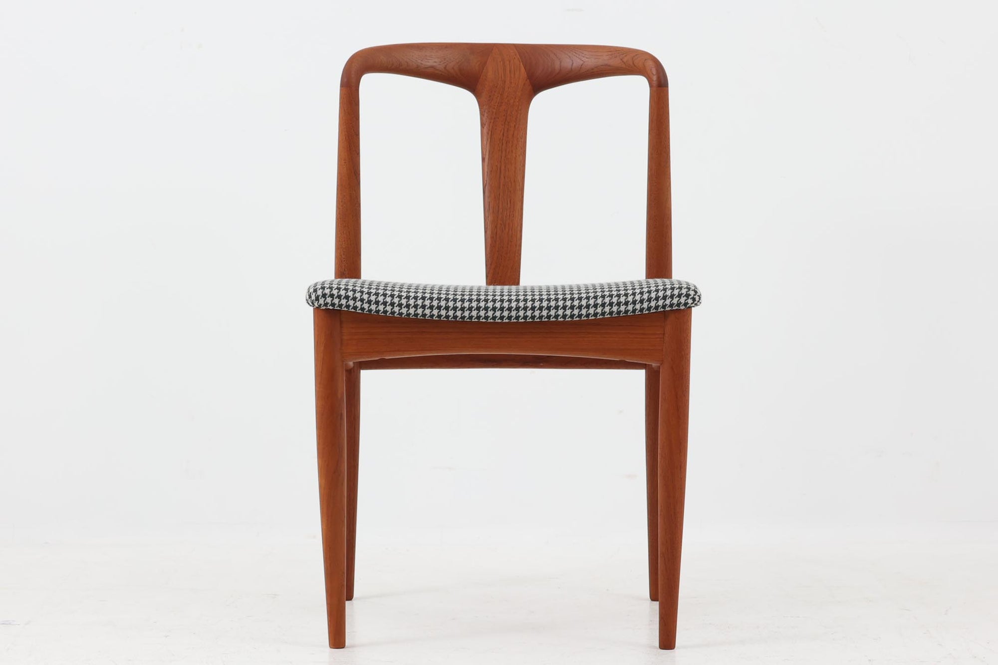 Johannes Andersenデザインの「Julian Chair」は、1960年代にUldum mobelfabrik社から発表されたチーク材のダイニングチェアです。特徴的な美しい曲線を描く背もたれと広めに設計された座面は、背中をしっかりと支え、快適な座り心地を提供します。彫刻的な軽快なフレームと実用性を兼ね備えたデザインが魅力的で、チーク材の温かみのある色味を引き立てています。