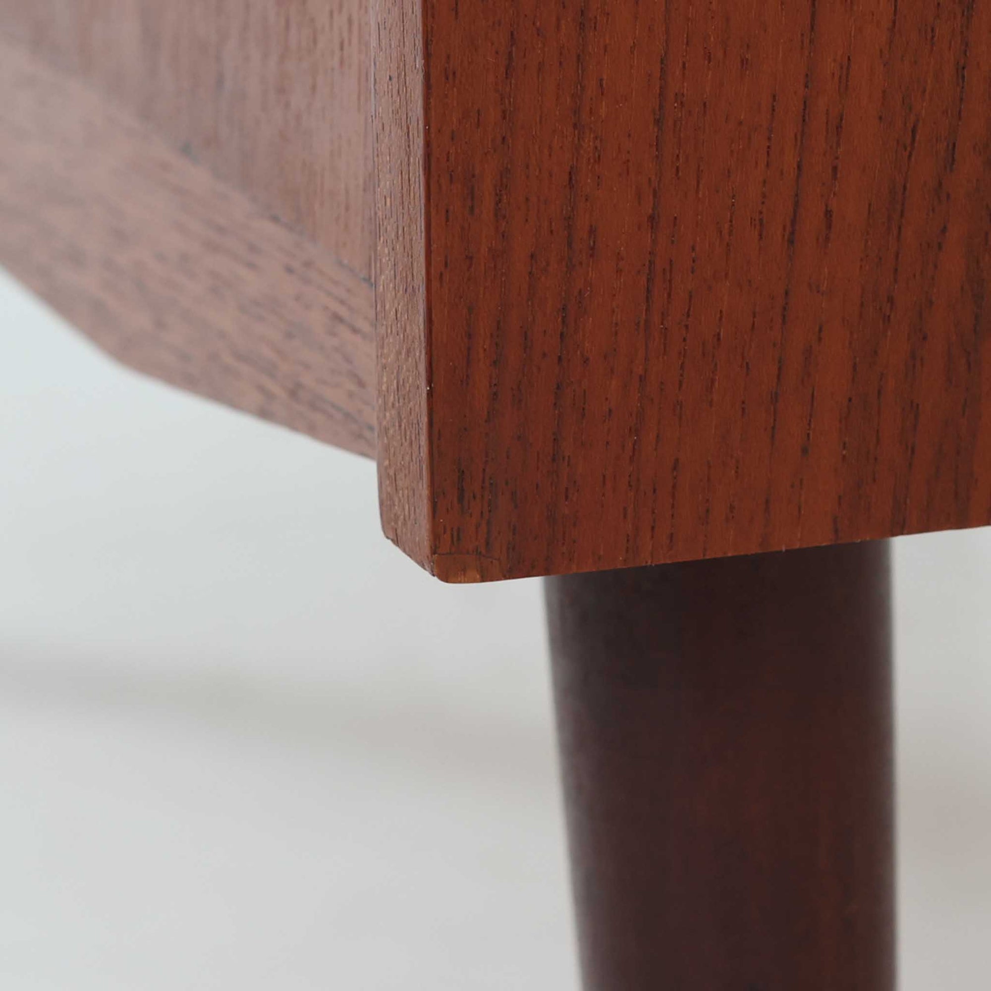 デンマーク製のチーク材によるライティングビューロです。幅85cmと程よいサイズ感で、上段には小引き出しを備え、小物や文具を整理しやすい構造になっています。中央のライティング天板は手前にスライドさせることで作業スペースが確保でき、書き物やノートPCの使用に最適です。さらに、内部には鏡が備わっており、ドレッサーとしても活用できる実用的なデザインです。下段には容量の大きな引き出しが3杯あり、衣類や書類の収納にも対応します。チーク材特有の温かみのある木目と経年による艶が味わい深く、実用性と美観を兼ね備えたビンテージ家具です。