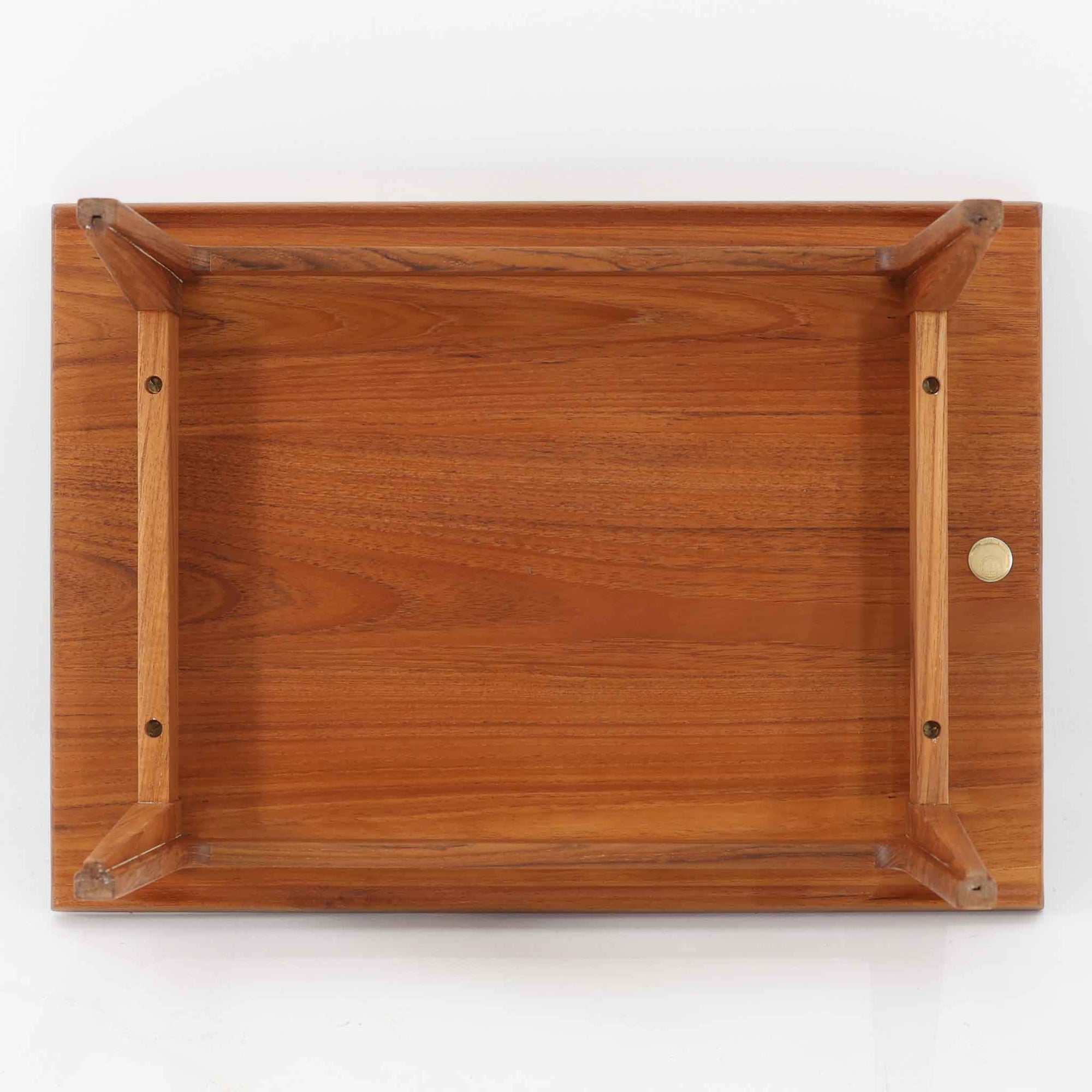 デンマークの巨匠フィン・ユールによるデザイン、France &amp; Son社製のサイドテーブル「FD635」です。ロゴより1957年頃に製造されたと推測される本品は、チーク無垢材を贅沢に使用し、滑らかな脚部の曲線と柔らかなエッジラインが見事に調和した美しいデザインが魅力です。天板の縁にはわずかな立ち上がりが設けられ、機能性と造形美を兼ね備えた構造となっています。彫刻的ともいえる有機的なフォルムはフィン・ユールの真骨頂であり、リビングやベッドサイドで北欧家具の上質な存在感を引き立てる逸品です。