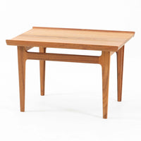 デンマークの巨匠フィン・ユールによるデザイン、France & Son社製のサイドテーブル「FD635」です。ロゴより1957年頃に製造されたと推測される本品は、チーク無垢材を贅沢に使用し、滑らかな脚部の曲線と柔らかなエッジラインが見事に調和した美しいデザインが魅力です。天板の縁にはわずかな立ち上がりが設けられ、機能性と造形美を兼ね備えた構造となっています。彫刻的ともいえる有機的なフォルムはフィン・ユールの真骨頂であり、リビングやベッドサイドで北欧家具の上質な存在感を引き立てる逸品です。