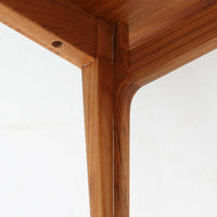 デンマークの巨匠フィン・ユールによるデザイン、France & Son社製のサイドテーブル「FD635」です。ロゴより1957年頃に製造されたと推測される本品は、チーク無垢材を贅沢に使用し、滑らかな脚部の曲線と柔らかなエッジラインが見事に調和した美しいデザインが魅力です。天板の縁にはわずかな立ち上がりが設けられ、機能性と造形美を兼ね備えた構造となっています。彫刻的ともいえる有機的なフォルムはフィン・ユールの真骨頂であり、リビングやベッドサイドで北欧家具の上質な存在感を引き立てる逸品です。