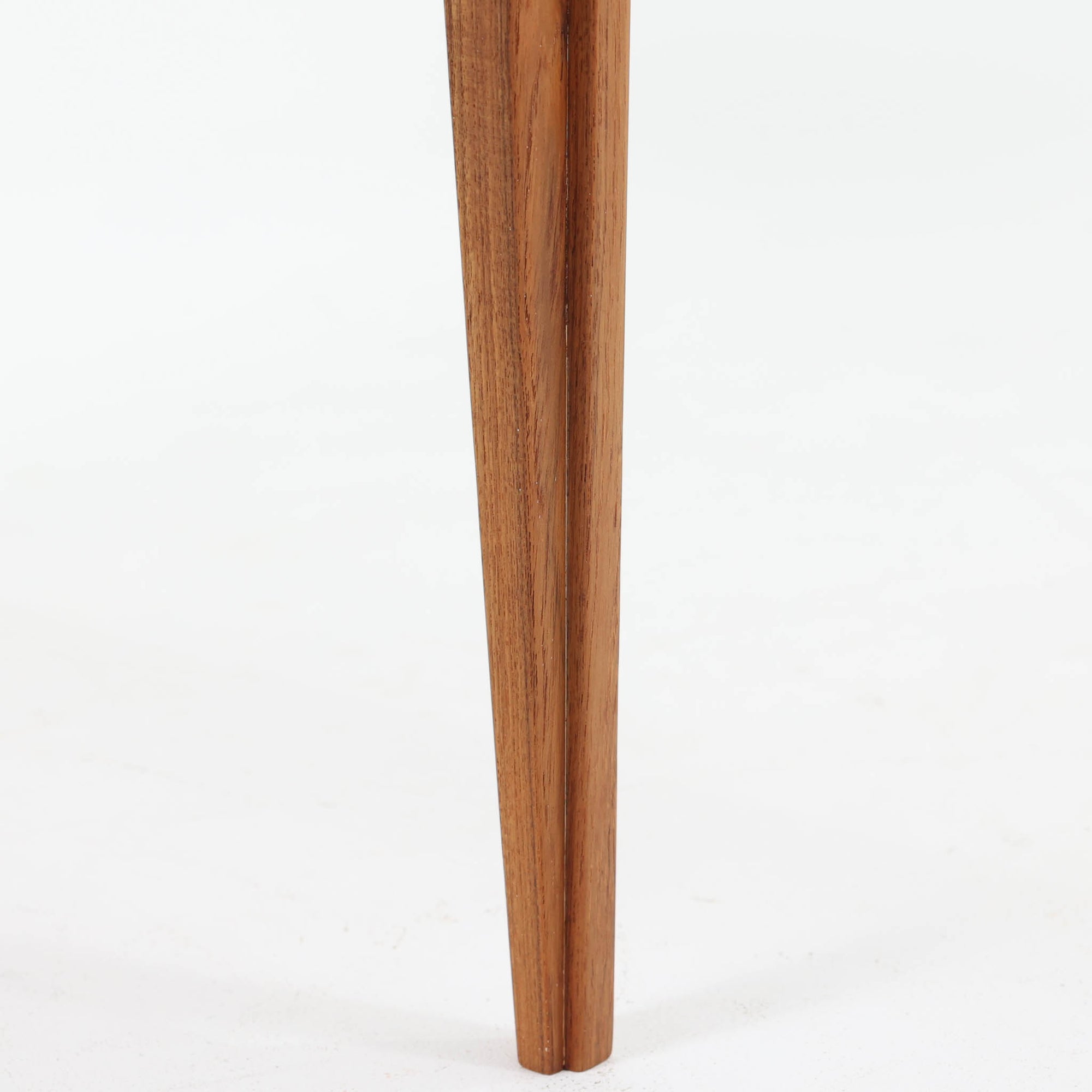 デンマークの巨匠フィン・ユールによるデザイン、France &amp; Son社製のサイドテーブル「FD635」です。ロゴより1957年頃に製造されたと推測される本品は、チーク無垢材を贅沢に使用し、滑らかな脚部の曲線と柔らかなエッジラインが見事に調和した美しいデザインが魅力です。天板の縁にはわずかな立ち上がりが設けられ、機能性と造形美を兼ね備えた構造となっています。彫刻的ともいえる有機的なフォルムはフィン・ユールの真骨頂であり、リビングやベッドサイドで北欧家具の上質な存在感を引き立てる逸品です。