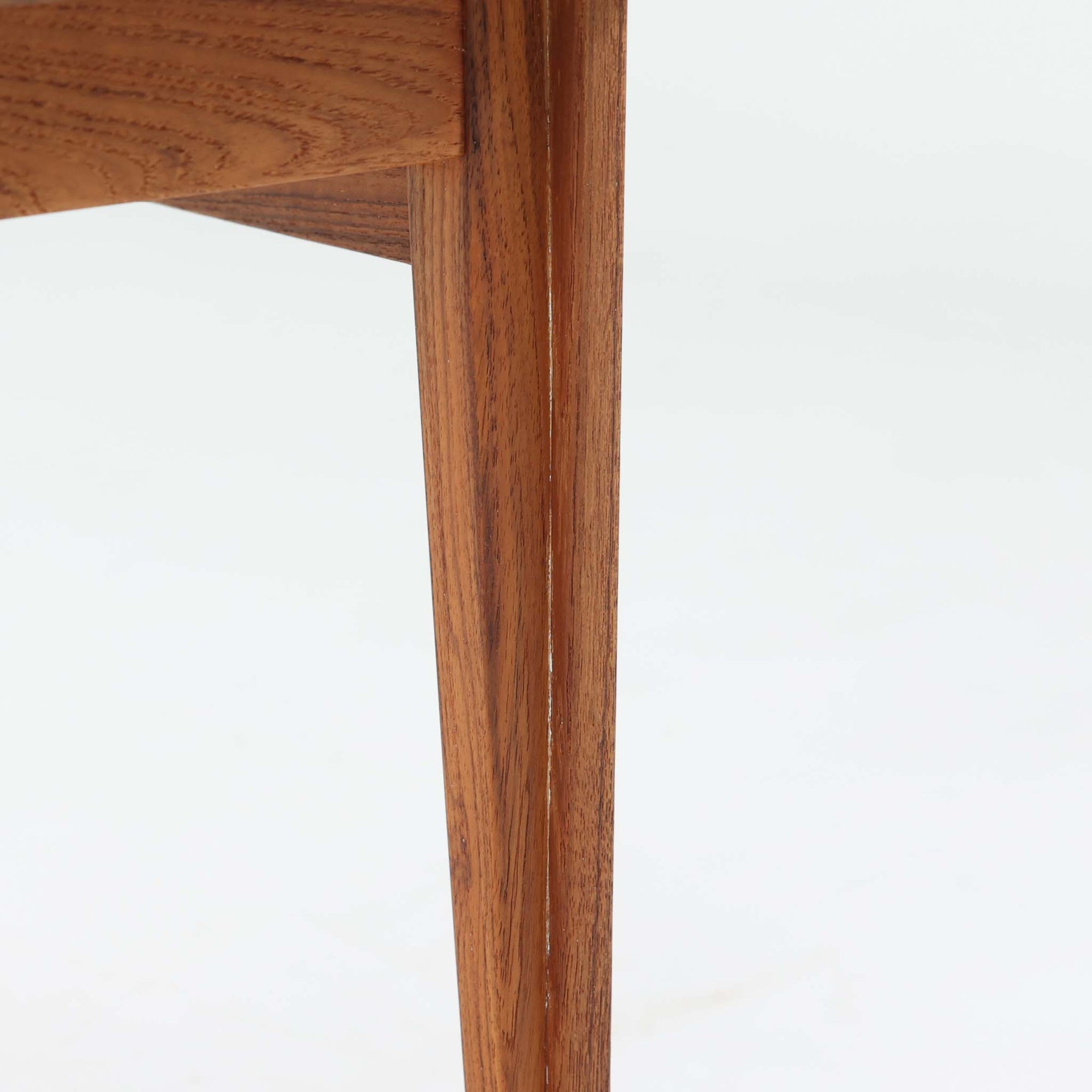 デンマークの巨匠フィン・ユールによるデザイン、France &amp; Son社製のサイドテーブル「FD635」です。ロゴより1957年頃に製造されたと推測される本品は、チーク無垢材を贅沢に使用し、滑らかな脚部の曲線と柔らかなエッジラインが見事に調和した美しいデザインが魅力です。天板の縁にはわずかな立ち上がりが設けられ、機能性と造形美を兼ね備えた構造となっています。彫刻的ともいえる有機的なフォルムはフィン・ユールの真骨頂であり、リビングやベッドサイドで北欧家具の上質な存在感を引き立てる逸品です。