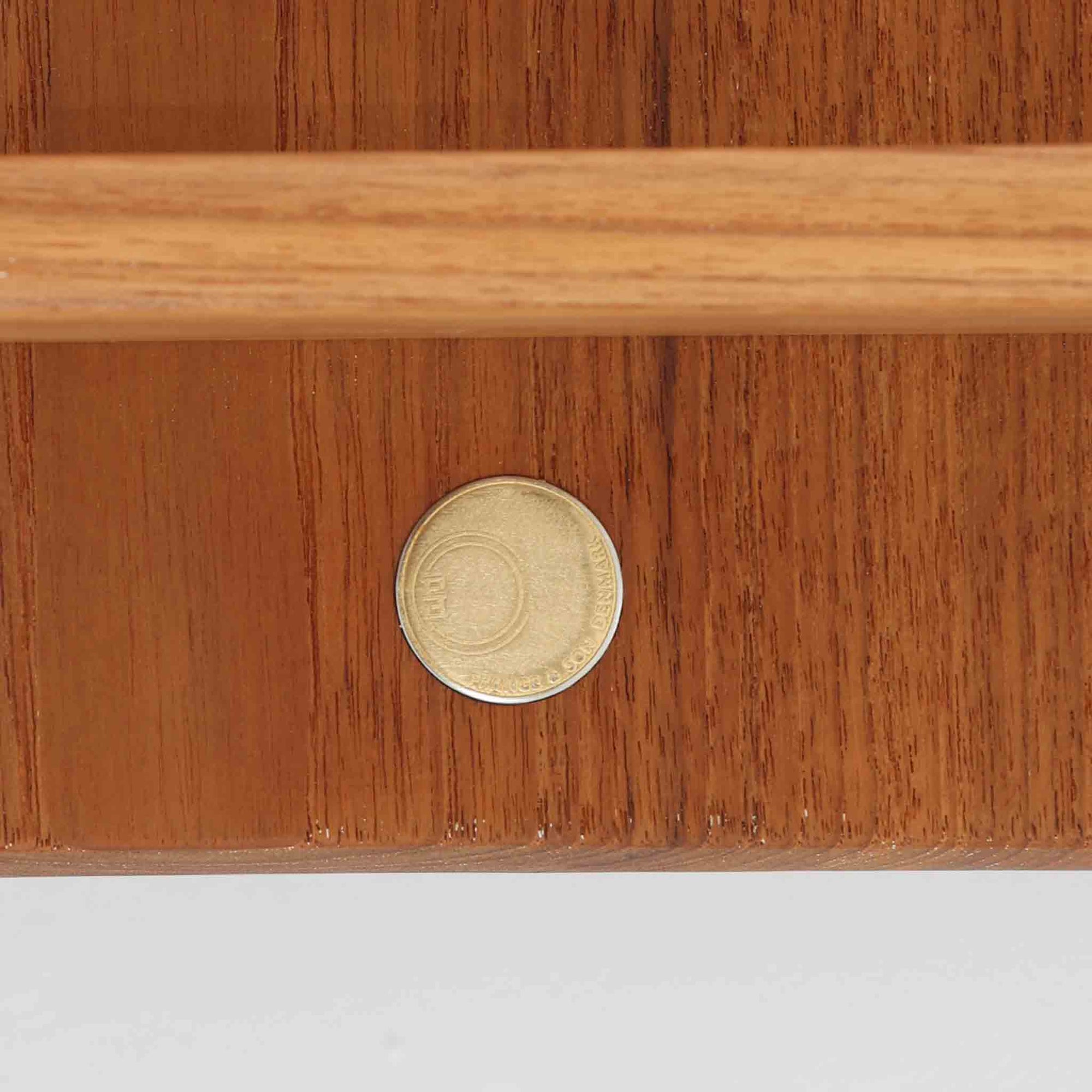 デンマークの巨匠フィン・ユールによるデザイン、France &amp; Son社製のサイドテーブル「FD635」です。ロゴより1957年頃に製造されたと推測される本品は、チーク無垢材を贅沢に使用し、滑らかな脚部の曲線と柔らかなエッジラインが見事に調和した美しいデザインが魅力です。天板の縁にはわずかな立ち上がりが設けられ、機能性と造形美を兼ね備えた構造となっています。彫刻的ともいえる有機的なフォルムはフィン・ユールの真骨頂であり、リビングやベッドサイドで北欧家具の上質な存在感を引き立てる逸品です。