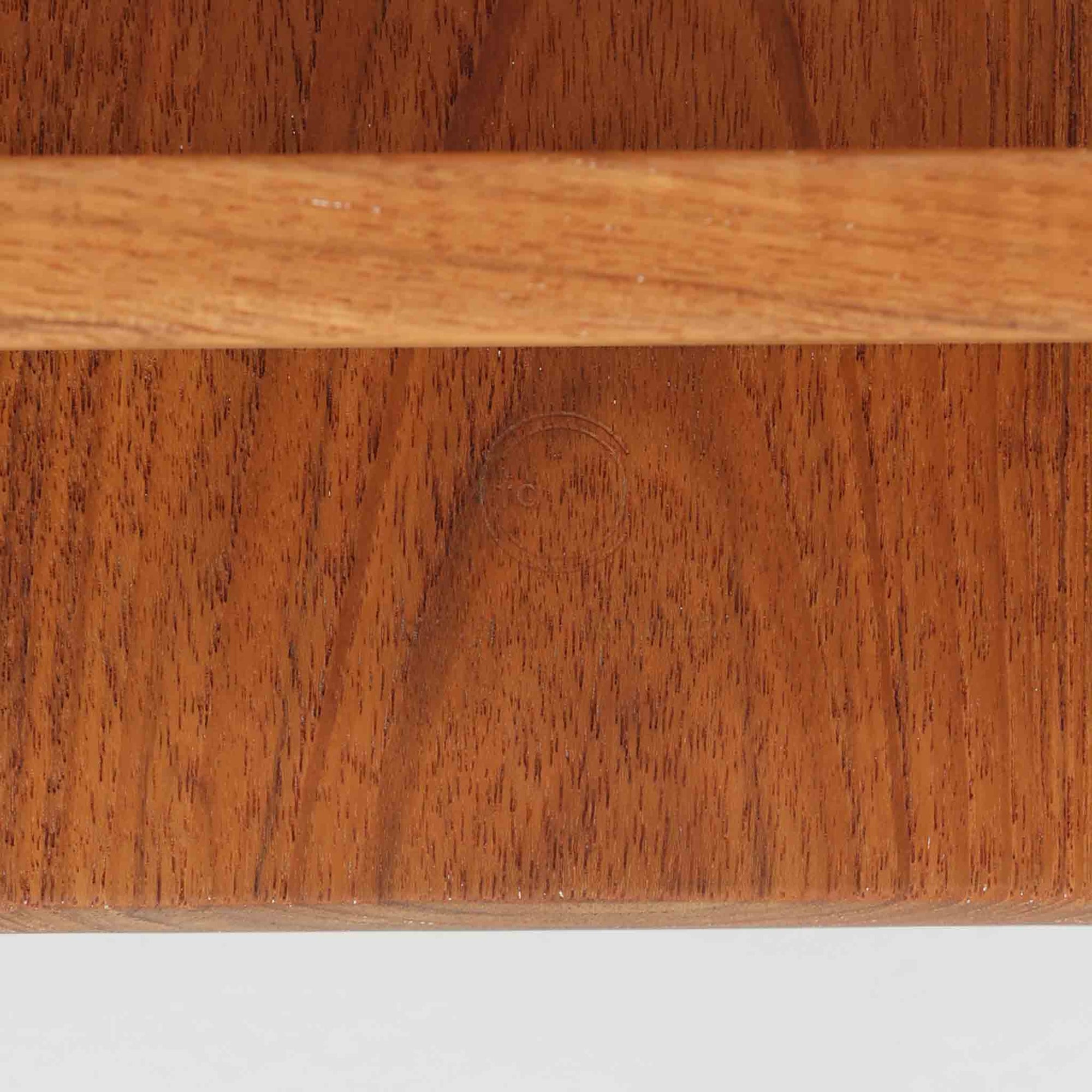 デンマークの巨匠フィン・ユールによるデザイン、France &amp; Son社製のサイドテーブル「FD635」です。ロゴより1957年頃に製造されたと推測される本品は、チーク無垢材を贅沢に使用し、滑らかな脚部の曲線と柔らかなエッジラインが見事に調和した美しいデザインが魅力です。天板の縁にはわずかな立ち上がりが設けられ、機能性と造形美を兼ね備えた構造となっています。彫刻的ともいえる有機的なフォルムはフィン・ユールの真骨頂であり、リビングやベッドサイドで北欧家具の上質な存在感を引き立てる逸品です。