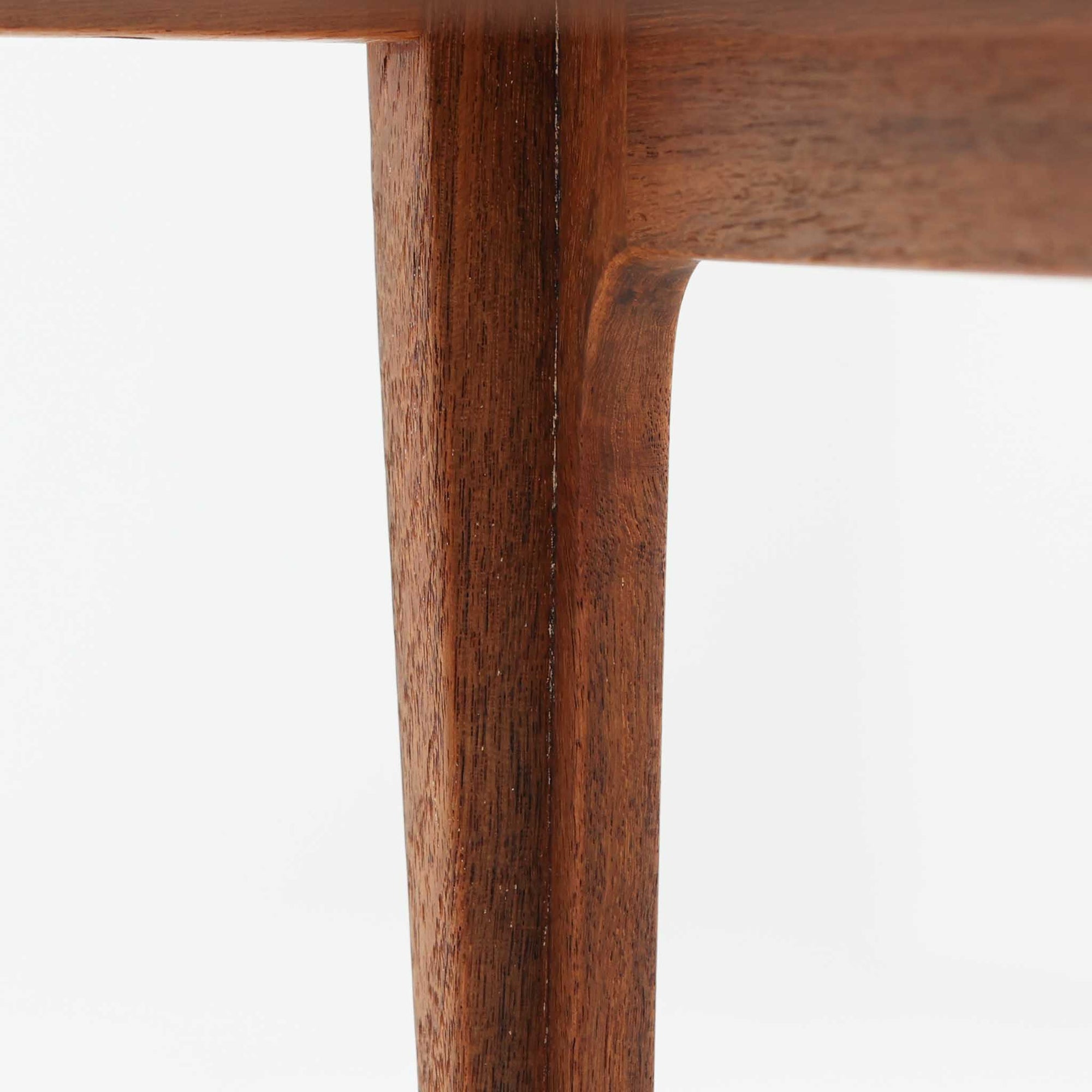 デンマークの巨匠フィン・ユールによるデザイン、France &amp; Son社製のサイドテーブル「FD635」です。ロゴより1957年頃に製造されたと推測される本品は、チーク無垢材を贅沢に使用し、滑らかな脚部の曲線と柔らかなエッジラインが見事に調和した美しいデザインが魅力です。天板の縁にはわずかな立ち上がりが設けられ、機能性と造形美を兼ね備えた構造となっています。彫刻的ともいえる有機的なフォルムはフィン・ユールの真骨頂であり、リビングやベッドサイドで北欧家具の上質な存在感を引き立てる逸品です。