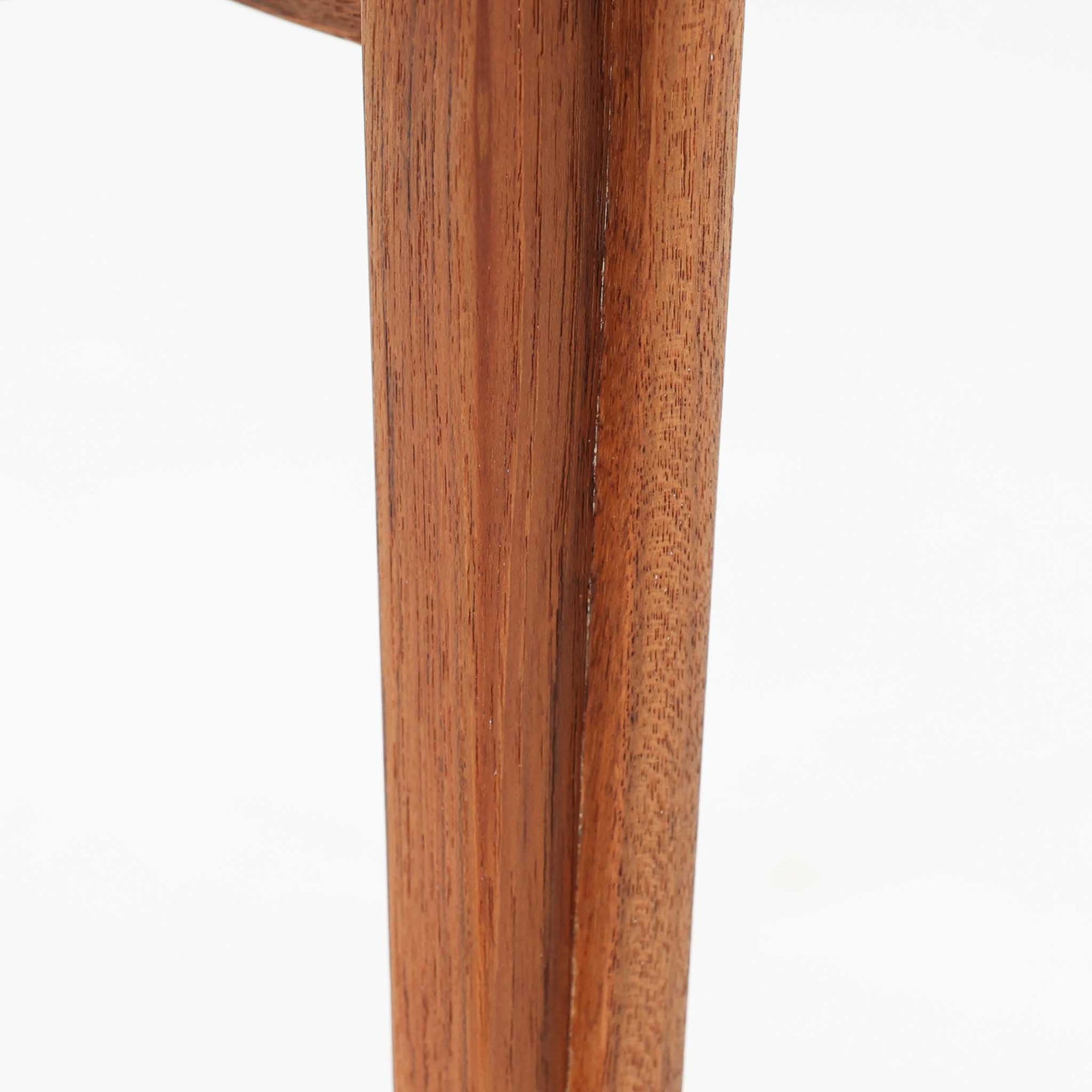 デンマークの巨匠フィン・ユールによるデザイン、France &amp; Son社製のサイドテーブル「FD635」です。ロゴより1957年頃に製造されたと推測される本品は、チーク無垢材を贅沢に使用し、滑らかな脚部の曲線と柔らかなエッジラインが見事に調和した美しいデザインが魅力です。天板の縁にはわずかな立ち上がりが設けられ、機能性と造形美を兼ね備えた構造となっています。彫刻的ともいえる有機的なフォルムはフィン・ユールの真骨頂であり、リビングやベッドサイドで北欧家具の上質な存在感を引き立てる逸品です。