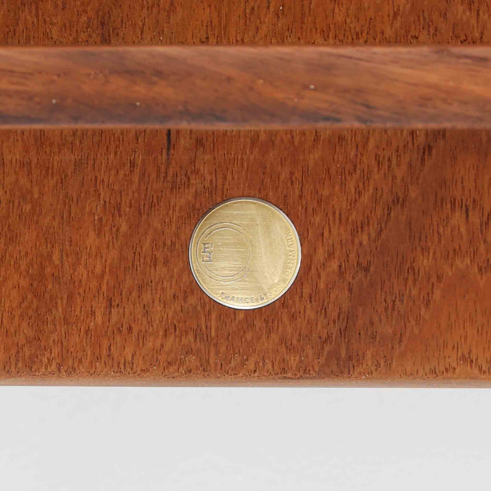 デンマークの巨匠フィン・ユールによるデザイン、France &amp; Son社製のサイドテーブル「FD635」です。ロゴより1957年頃に製造されたと推測される本品は、チーク無垢材を贅沢に使用し、滑らかな脚部の曲線と柔らかなエッジラインが見事に調和した美しいデザインが魅力です。天板の縁にはわずかな立ち上がりが設けられ、機能性と造形美を兼ね備えた構造となっています。彫刻的ともいえる有機的なフォルムはフィン・ユールの真骨頂であり、リビングやベッドサイドで北欧家具の上質な存在感を引き立てる逸品です。