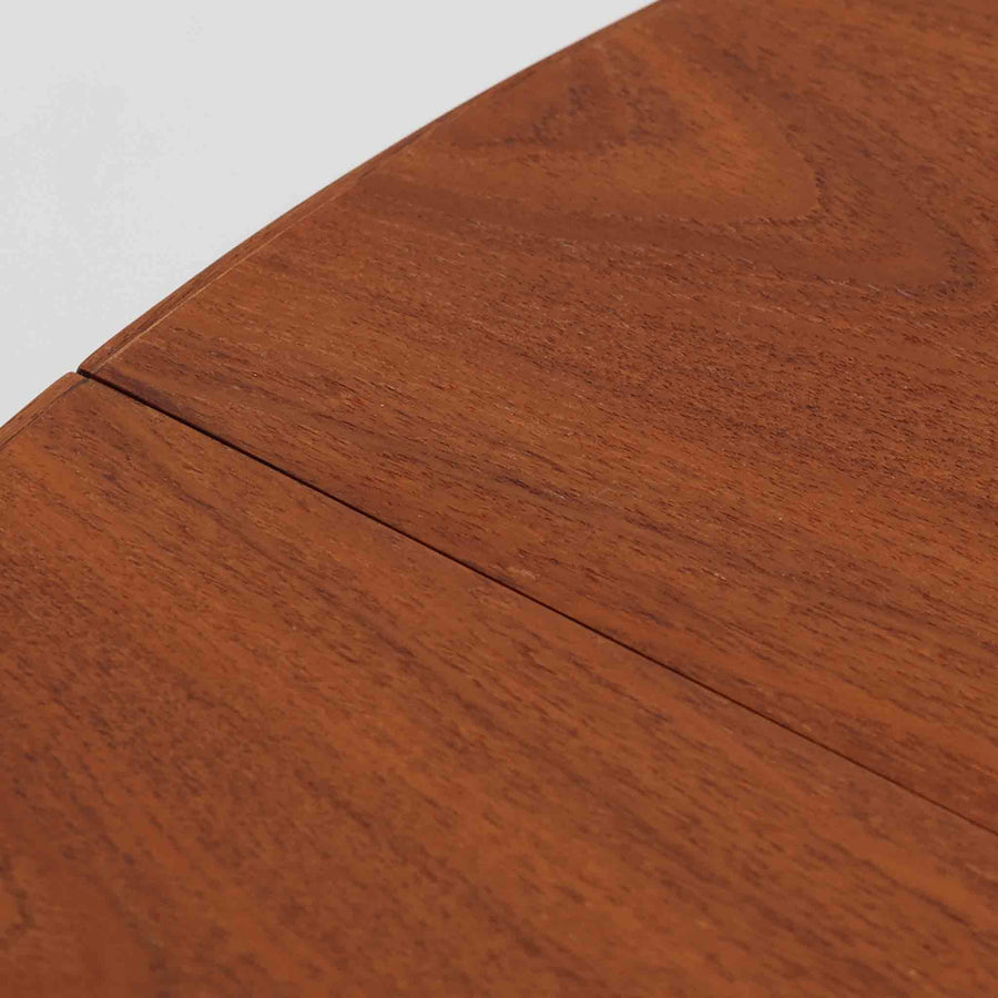 デンマーク製円形エクステンションダイニングテーブルです。チーク材特有の温かみある木目が美しく、滑らかな質感が空間に上質な印象を与えます。幕板と天板が一体化した構造により、すっきりとした見た目と安定感のある構造を両立。天板中央の拡張板を取り付けることで人数や用途に合わせてサイズを調整でき、普段使いから来客時まで幅広く対応します。テーパー脚が軽やかな印象を添え、経年で深みを増したチークの色合いが北欧ビンテージならではの魅力を引き立てます。