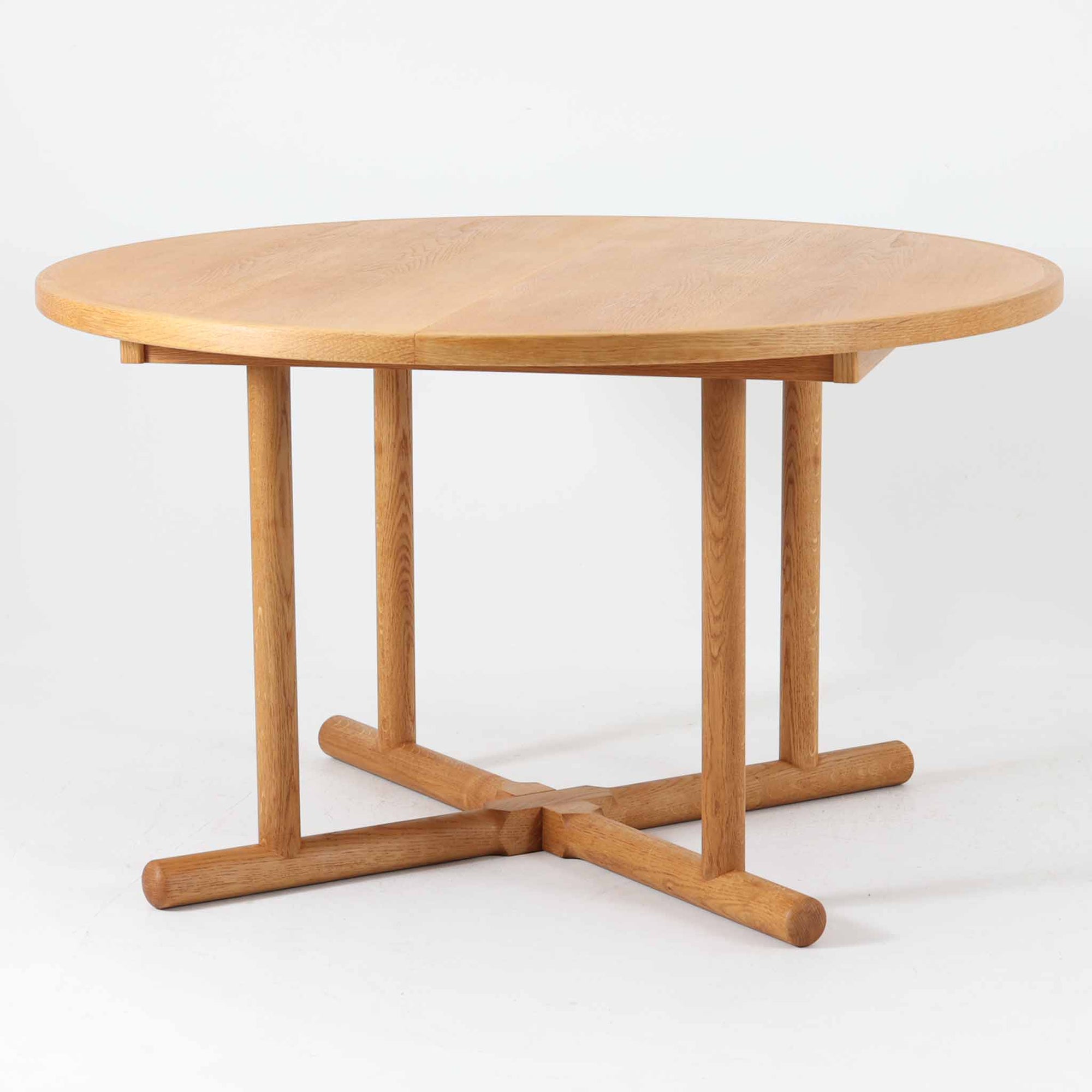 デンマークのデザイナー、Kurt Ostervig（カート・ウストヴィ）が手がけ、Jason Mobler社から発表された円形エクステンションダイニングテーブル。美しいオーク材の木目と、円形から楕円形へと広がる機能性を兼ね備えた一台です。交差する脚部の構造が彫刻的な存在感を放ち、視覚的な安定感も演出します。中央のリーフを追加することで来客時にも対応でき、実用性とデザイン性を両立。経年によるオーク材の味わい深い表情と丁寧な仕上げが、北欧ビンテージ家具ならではの魅力を感じさせます。ダイニングだけでなく、作業台としての使用にもおすすめです。