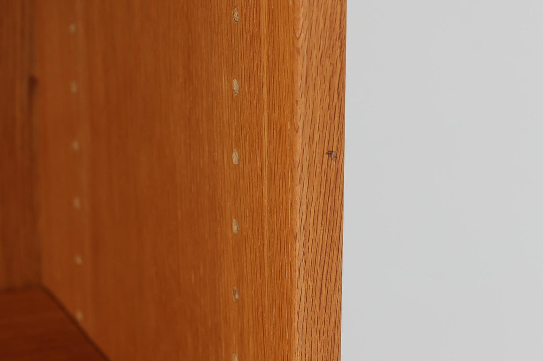 北欧より買い付けたHans J. Wegnerデザインのブックシェルフです。 彼のキャビネット類を数多く手がけたRY mobler社製の本棚です。本体はオーク材が使用されています。 シンプルなデザインながらも要所要所にウェグナーらしいデザインが施してあり、実用性にも優れている逸品です。高さがあるため使用中には見えにくいですが、天板に輪染みがあるため、お求めやすい価格に設定しています。