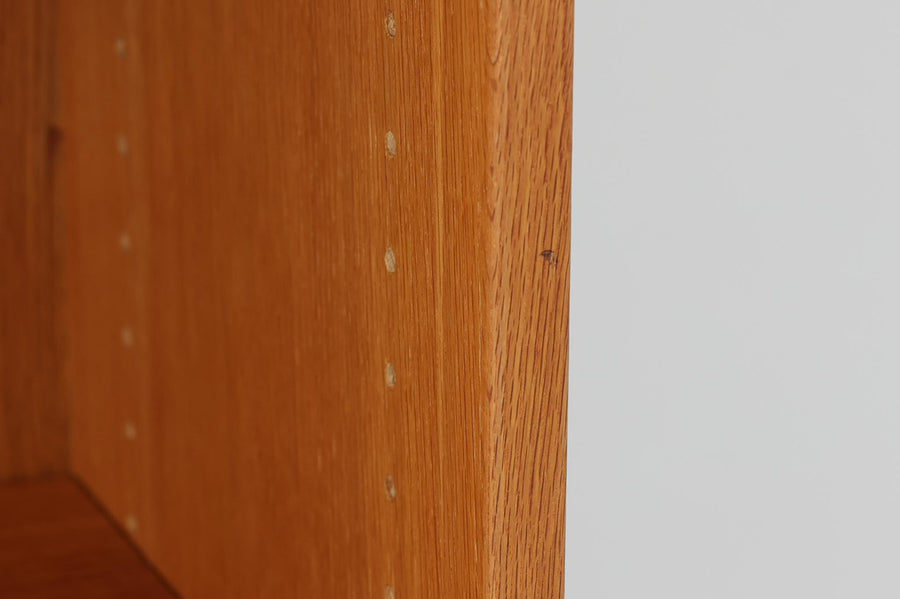 北欧より買い付けたHans J. Wegnerデザインのブックシェルフです。 彼のキャビネット類を数多く手がけたRY mobler社製の本棚です。本体はオーク材が使用されています。 シンプルなデザインながらも要所要所にウェグナーらしいデザインが施してあり、実用性にも優れている逸品です。高さがあるため使用中には見えにくいですが、天板に輪染みがあるため、お求めやすい価格に設定しています。