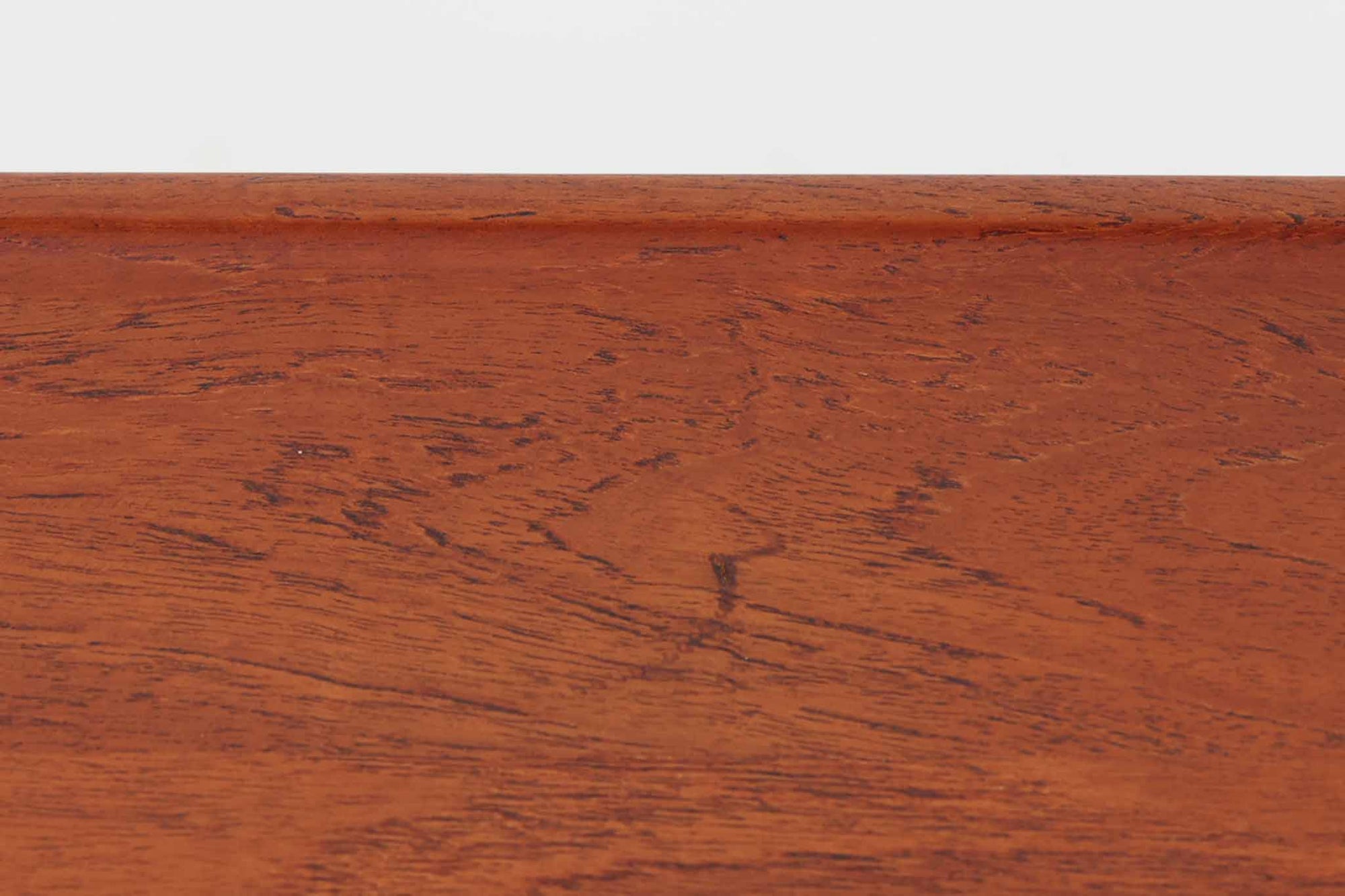 北欧より買い付けた、Hans J. WegnerによるAT10です。天板にはチーク無垢材が使われ、脚部にはオーク無垢材が採用されています。経年変化した籐の棚が特徴的で、温かみのある雰囲気を醸し出します。幅160cmというサイズ感は、3Pソファの前面に並べて使用すると、程良い距離感を保ちながら使いやすく、空間全体のバランスを整えます。縁が削り出されて丸みを帯びたデザインは、AT10の特徴であり、その独特の魅力が感じられます。天板裏面にはAndreas Tuck社の刻印がございます。