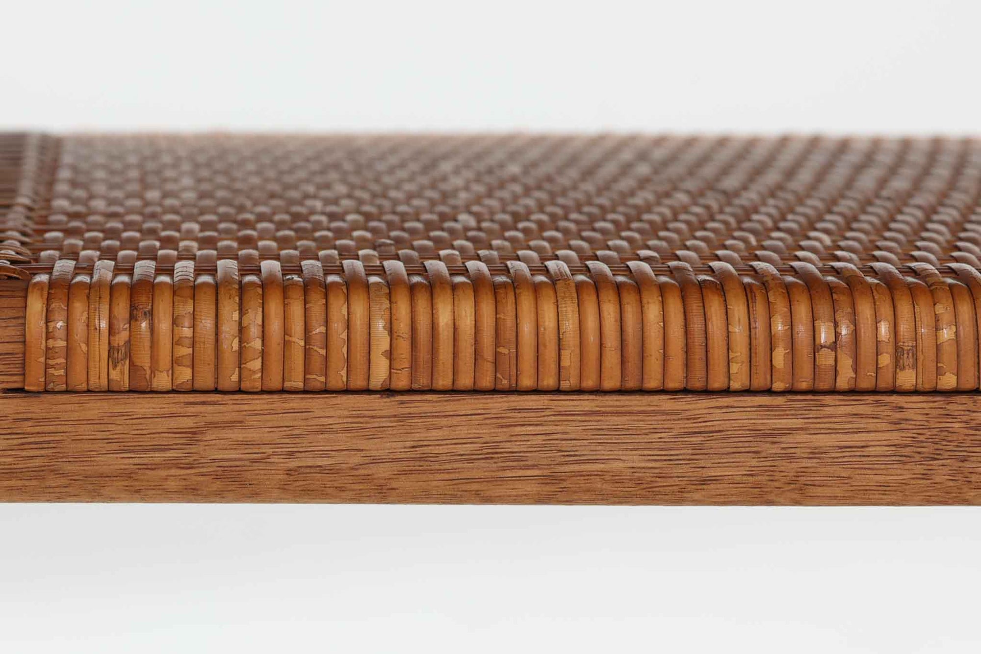 北欧より買い付けた、Hans J. WegnerによるAT10です。天板にはチーク無垢材が使われ、脚部にはオーク無垢材が採用されています。経年変化した籐の棚が特徴的で、温かみのある雰囲気を醸し出します。幅160cmというサイズ感は、3Pソファの前面に並べて使用すると、程良い距離感を保ちながら使いやすく、空間全体のバランスを整えます。縁が削り出されて丸みを帯びたデザインは、AT10の特徴であり、その独特の魅力が感じられます。天板裏面にはAndreas Tuck社の刻印がございます。