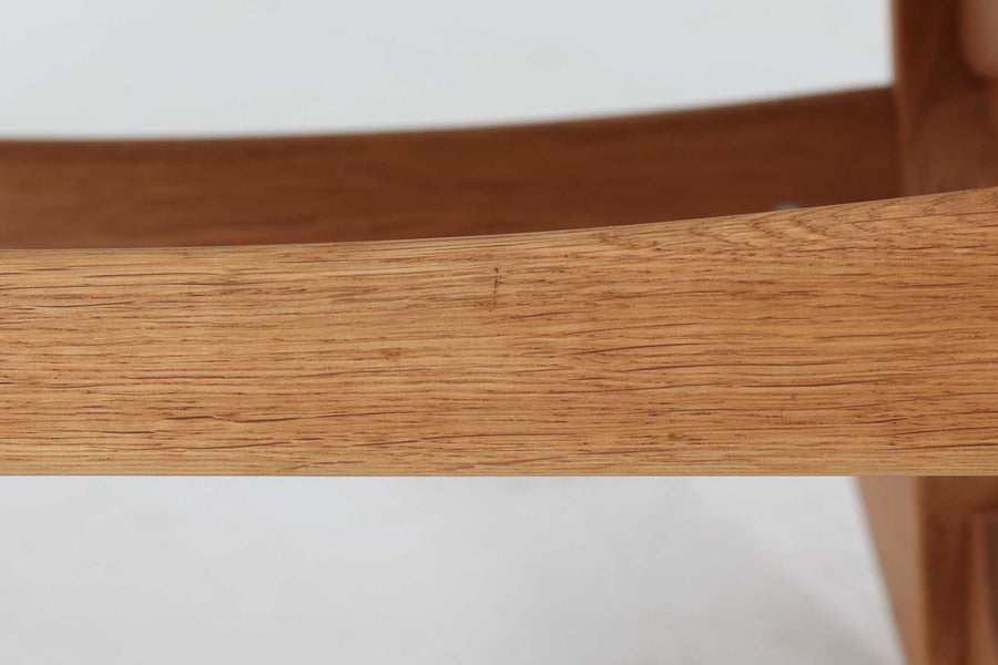 Hans J. Wegnerが1967年にデザインしたロッキングチェア「キーホールチェア（GE673）」は、GETAmA社製の一脚です。特徴的な「鍵穴」のような形状の座面固定方法が名前の由来で、左右のアーム下に引っ掛けた2本の棒が座面を支える構造です。帆布製の背もたれと座面は、ハンモックのような座り心地を提供し、まるで包み込まれるような安心感を感じさせます。ロッキングチェアならではの揺れと、程よい可動領域が特徴で、家の中でゆったりとくつろぐのに最適です。座面は簡単に取り外せ、クリーニングにも配慮されています。軽量で機能性とデザインが見事に調和した、ウェグナーならではの作品です。