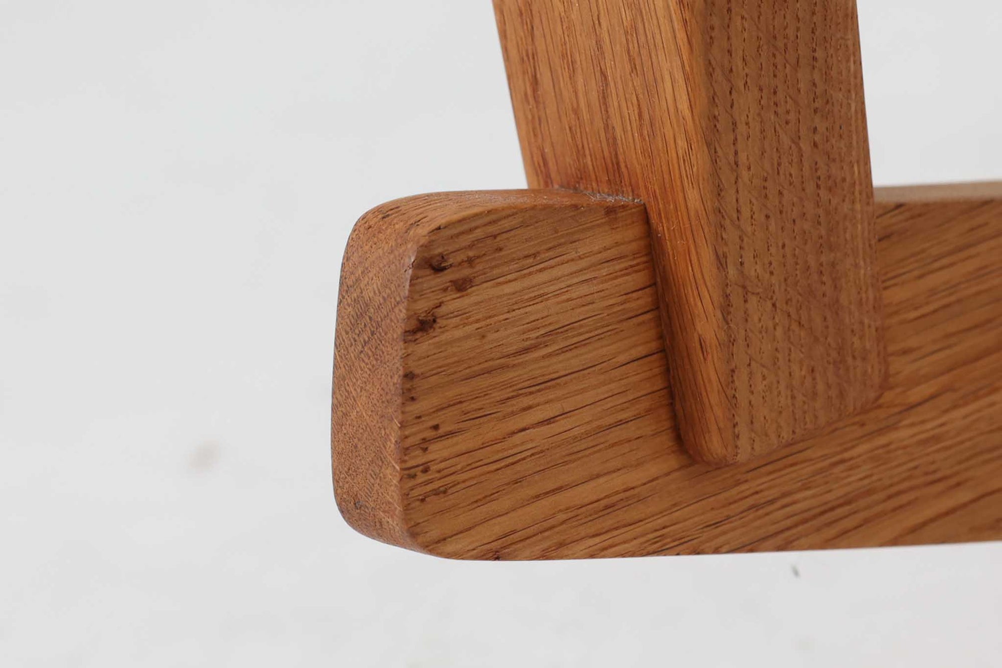 Hans J. Wegnerが1967年にデザインしたロッキングチェア「キーホールチェア（GE673）」は、GETAmA社製の一脚です。特徴的な「鍵穴」のような形状の座面固定方法が名前の由来で、左右のアーム下に引っ掛けた2本の棒が座面を支える構造です。帆布製の背もたれと座面は、ハンモックのような座り心地を提供し、まるで包み込まれるような安心感を感じさせます。ロッキングチェアならではの揺れと、程よい可動領域が特徴で、家の中でゆったりとくつろぐのに最適です。座面は簡単に取り外せ、クリーニングにも配慮されています。軽量で機能性とデザインが見事に調和した、ウェグナーならではの作品です。