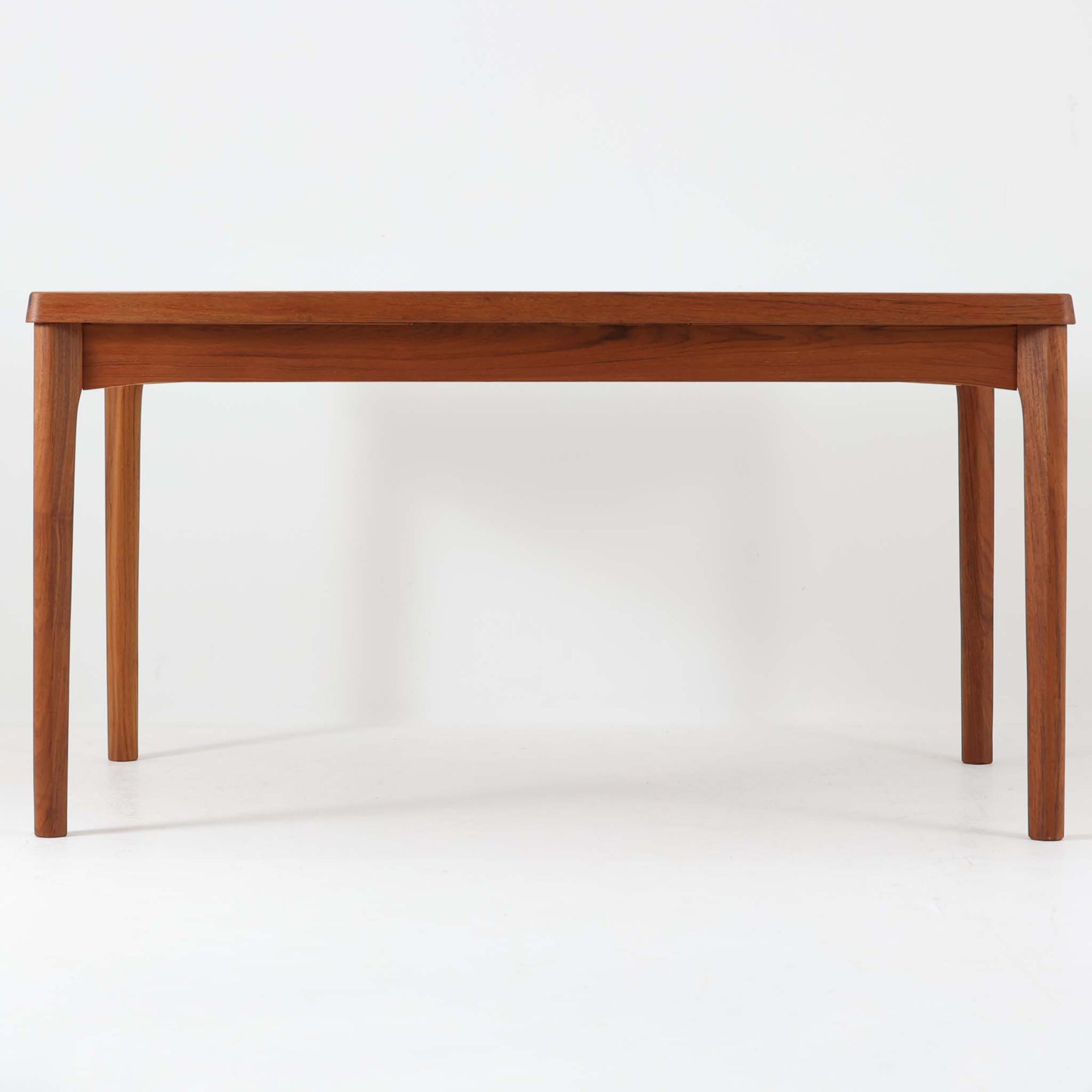 Henning Kjaernulf（ヘニング・ケアヌルフ）によってデザインされ、Vejle Stole og Mobelfabrik社が製造したデンマーク製のエクステンションダイニングテーブル。温もりあるチーク材と美しく面取りされたエッジラインが特徴です。両端のリーフを引き出すだけで最大239cmまで拡張でき、日常使いから来客時まで柔軟に対応。脚部はすっきりとした削り出しのディテールが施され、軽やかさと安定感を両立しています。素材の上質さと機能美を兼ね備えた、北欧ビンテージ家具の魅力あふれる一台です。