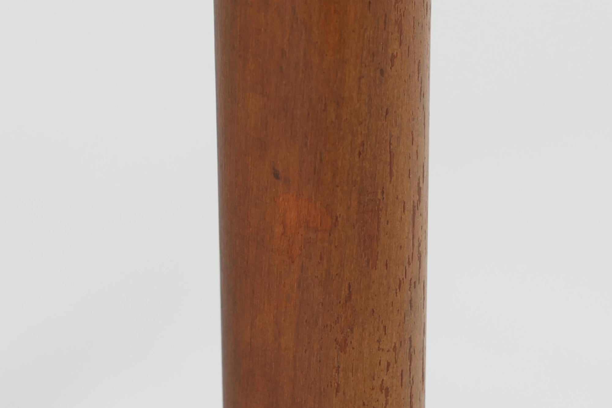 台形を基にした多角形の天板が特徴的な、美しいビンテージのセンターテーブル。心地よい木目が際立つウォールナット材の天板と、ナチュラルな風合いのビーチ材の組み合わせが、温かみのある佇まいを演出しています。天板と脚部、棚板の接続部には丸い真鍮があしらわれ、シンプルなフォルムの中に洗練されたアクセントを加えています。また、脚部をつなぐ幕板の形状も独特で、細部にまでこだわりが感じられるデザインです。デザイナーは不明ですが、細部の仕上げや素材選びから高いクオリティがうかがえる一品。モダンとクラシックが絶妙に調和した、上質なビンテージテーブルです。