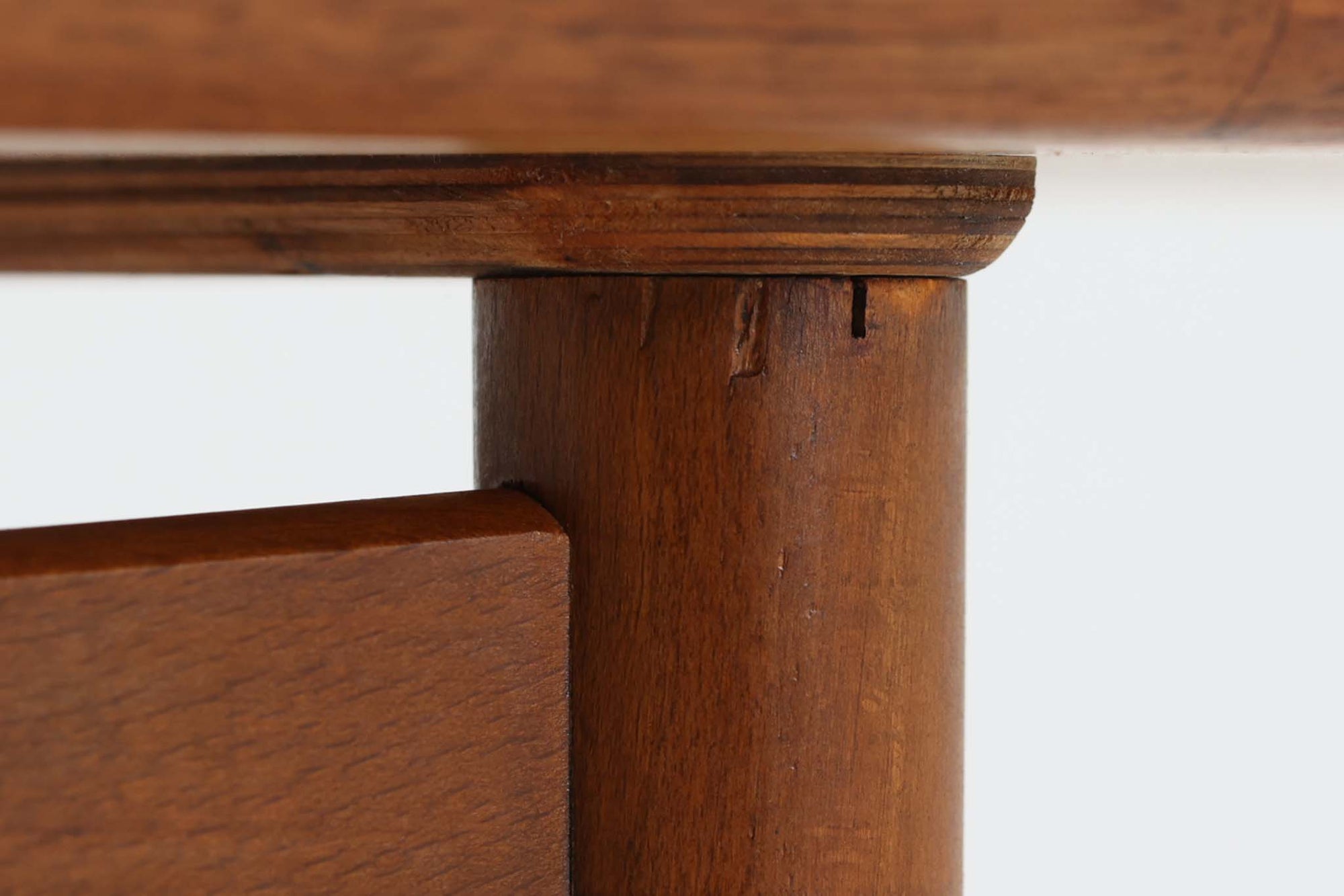 台形を基にした多角形の天板が特徴的な、美しいビンテージのセンターテーブル。心地よい木目が際立つウォールナット材の天板と、ナチュラルな風合いのビーチ材の組み合わせが、温かみのある佇まいを演出しています。天板と脚部、棚板の接続部には丸い真鍮があしらわれ、シンプルなフォルムの中に洗練されたアクセントを加えています。また、脚部をつなぐ幕板の形状も独特で、細部にまでこだわりが感じられるデザインです。デザイナーは不明ですが、細部の仕上げや素材選びから高いクオリティがうかがえる一品。モダンとクラシックが絶妙に調和した、上質なビンテージテーブルです。