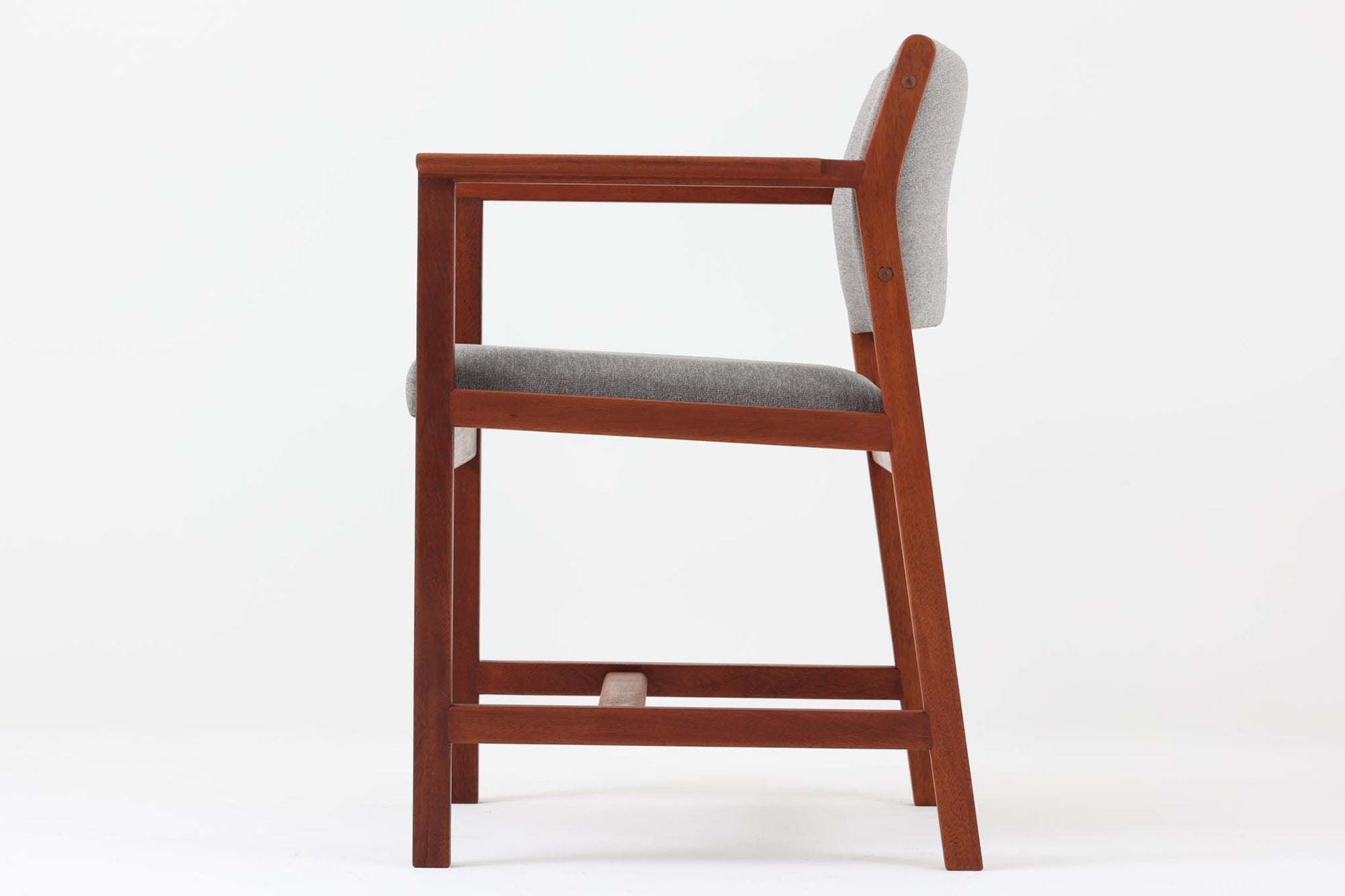 Bm73チェアは、Børge mogensen（ボーエ・モーエンセン）がデザインした、直線を基調とした端正なフォルムが魅力の一品です。本体には良質なマホガニー材が使用され、要所に曲線を取り入れることで、シンプルながらも洗練された印象を与えています。アーム付きのデザインは快適な座り心地を提供し、特にアーム先端の繋ぎ目は細部までこだわりを感じさせるデザインポイントです。脚部に大きめのあたり傷があるため、その点を考慮した価格となっております。傷がある部分も味わいとして捉えることができ、ビンテージ品の一環としてご理解いただければと思います。