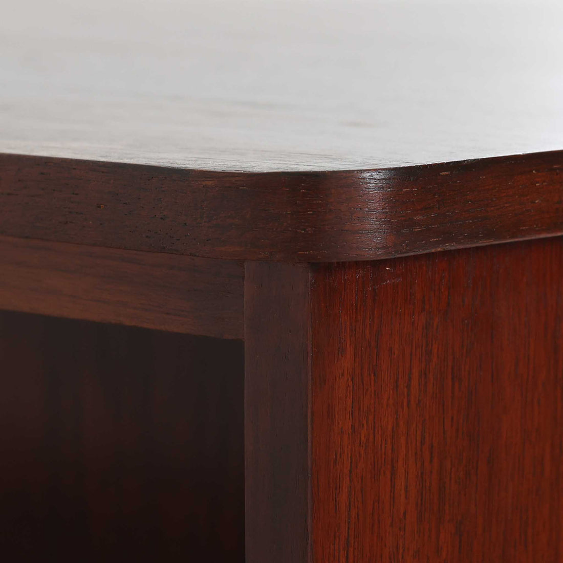 デンマーク製キドニーデスクです。緩やかな曲線を描く天板と、右側に配された蛇腹扉収納が特徴的な美しいデザインで、北欧モダンの洗練された造形美が感じられます。上質なチーク材が用いられ、深みのある色合いと木目が経年により一層味わいを増しています。背面にも収納棚を備えており、空間の中央に置いても様になる造りです。書斎デスクとしてはもちろん、ショップのカウンターや作業台としても活躍する存在感のある一台です。