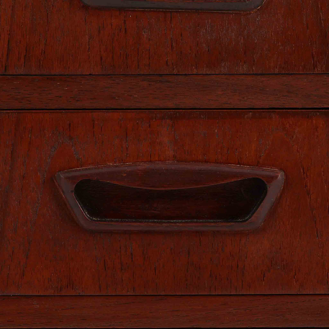 デンマーク製キドニーデスクです。緩やかな曲線を描く天板と、右側に配された蛇腹扉収納が特徴的な美しいデザインで、北欧モダンの洗練された造形美が感じられます。上質なチーク材が用いられ、深みのある色合いと木目が経年により一層味わいを増しています。背面にも収納棚を備えており、空間の中央に置いても様になる造りです。書斎デスクとしてはもちろん、ショップのカウンターや作業台としても活躍する存在感のある一台です。