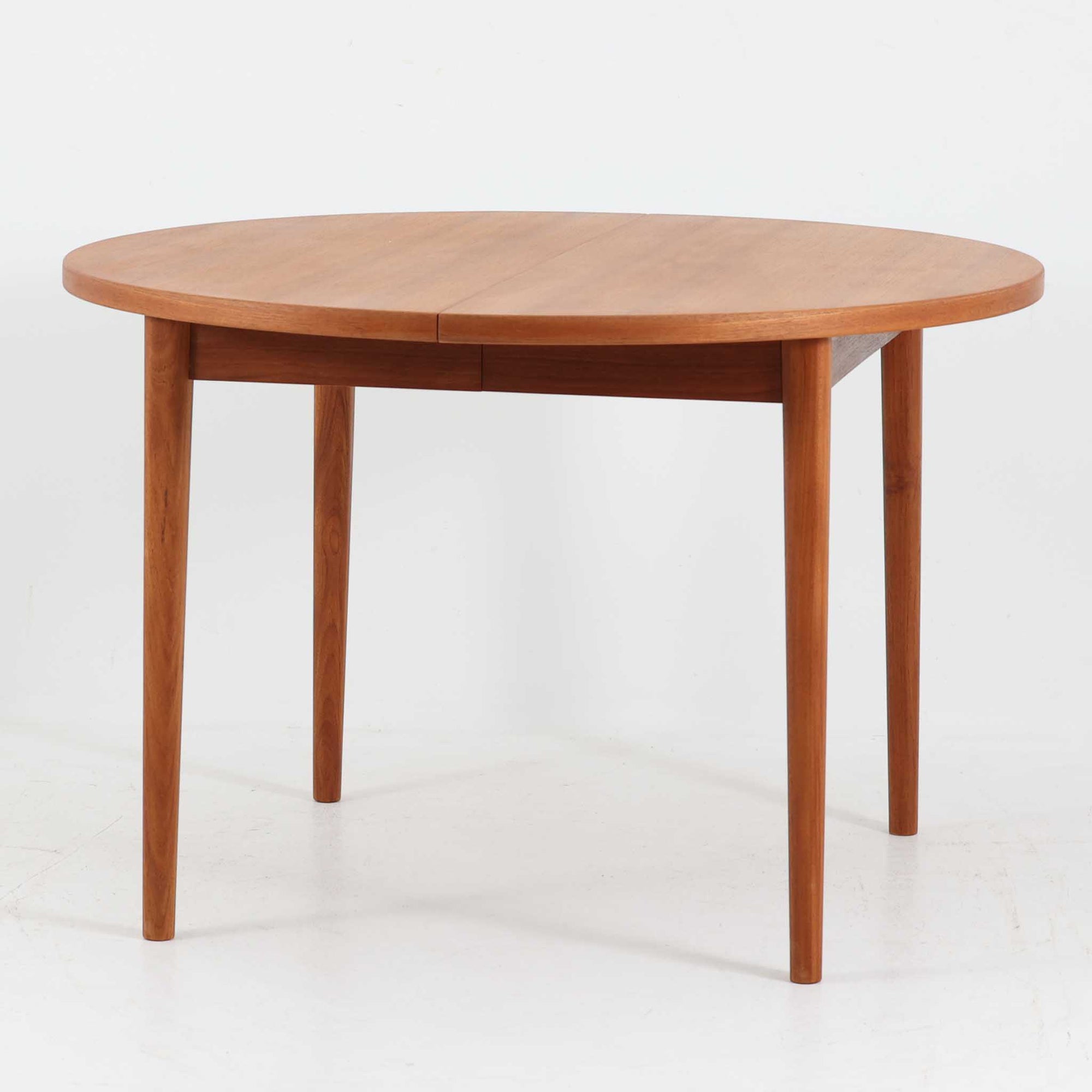 Nils Jonssonがデザインし、Troeds社より発表された円形エクステンションダイニングテーブル「Malta」です。チーク材の温かみある木目が美しく、直径110cmの天板は来客時には拡張板を追加することで大きな楕円形へと広がり、シーンに応じた柔軟な使い方が可能です。拡張板は円形では珍しく折り畳んで本体に収納することができ、機能性と利便性を兼ね備えています。脚部は細身で軽快ながら安定感があり、北欧家具らしいシンプルで機能的な構造が魅力です。日常使いはもちろん、来客時や家族の集まりにも最適で、経年による素材の風合いがビンテージならではの味わいを深めています。