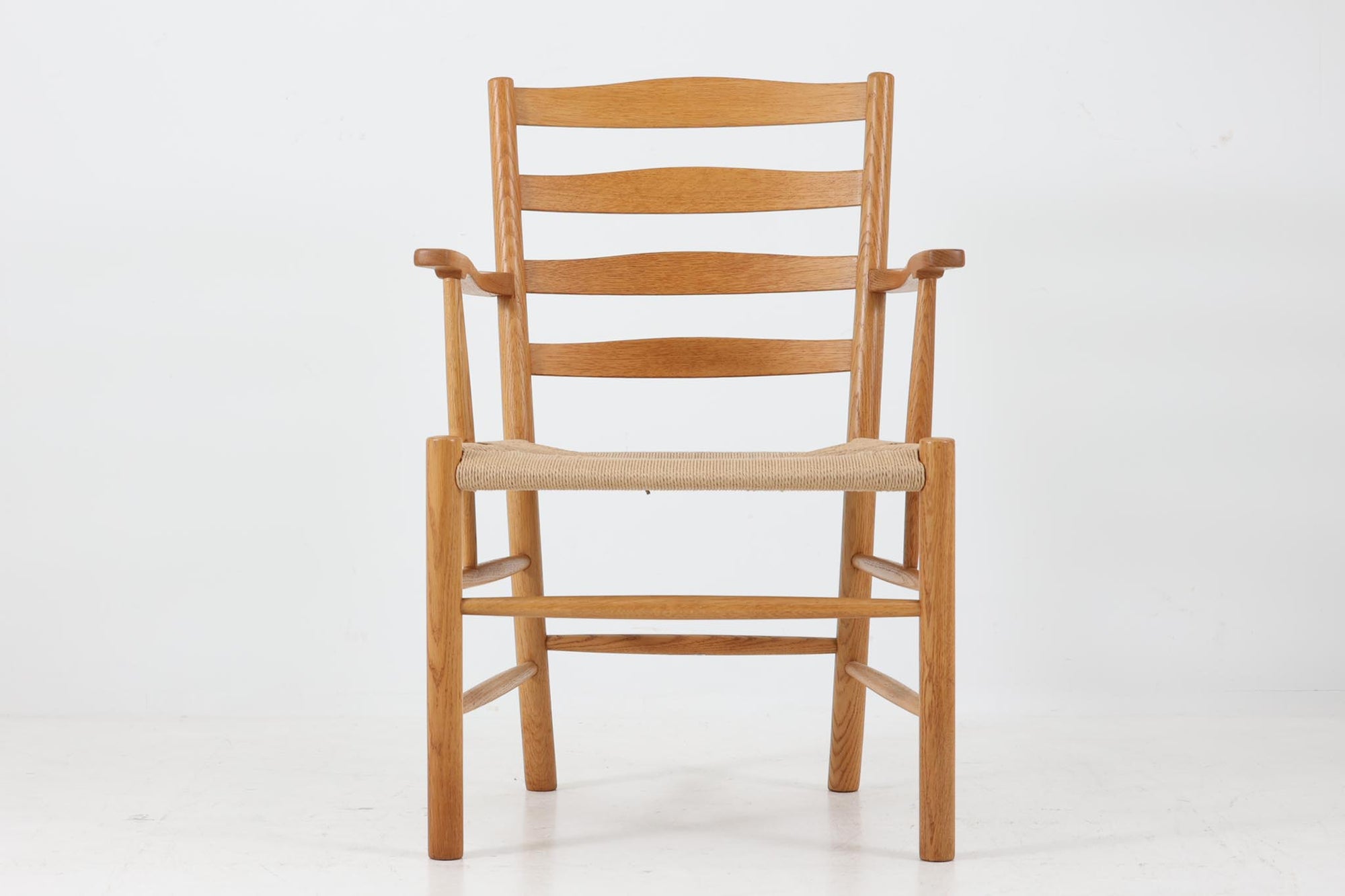 コーア・クリントのチャーチチェアは、1930年代に発表された彼の代表作の一つで、シンプルながら美しいラインと優れた座り心地を兼ね備えています。教会用に設計されたこの椅子は、長時間座っていても疲れにくいことが特徴で、その機能性と美しさから非常に高い評価を受けています。特に、1936年からフリッツ・ハンセン社で製造されたオリジナルモデルは、教会用にデザインされたものとして非常に希少であり、ヴィンテージ市場では非常に高額で取引されています。1990年代から2000年代初頭にかけて、フリッツ・ハンセン社によって再販され、コーア・クリントのデザインは広く認知されました。再販モデルはオリジナルを忠実に再現し、現代のインテリアにも人気があります。シンプルで機能的なデザインは今なお多くの人々に愛され、インテリア愛好者やコレクターに高く評価されています。こちらのチェアは、フリッツ・ハンセンから販売された比較的新しい再販モデルで、オリジナルの魅力を現代に適応させた一品です。