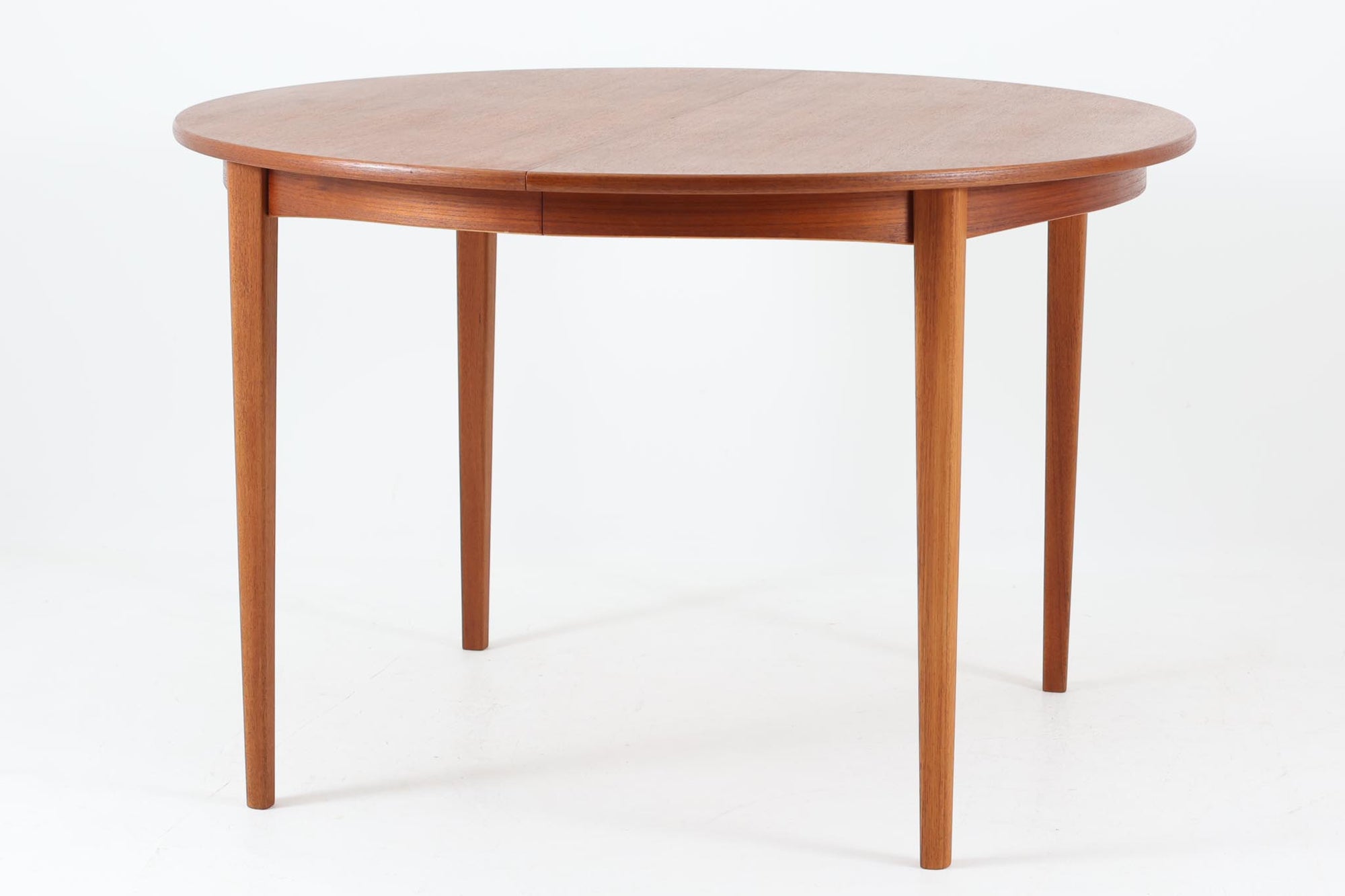 北欧デンマークより買い付けたビンテージの円形ダイニングテーブルです。美しいチーク材の木目が上品な印象で、北欧らしい温かみと洗練を兼ね備えたデザインです。天板は、幅112cmから162cmへと拡張が可能なエクステンションタイプとなっています。普段はコンパクトに、来客時には広々と使用できる実用性に優れた構造で、先細りの丸脚が軽やかな印象を与えます。シンプルながらも上質な造りで、空間にすっと溶け込む一台です。