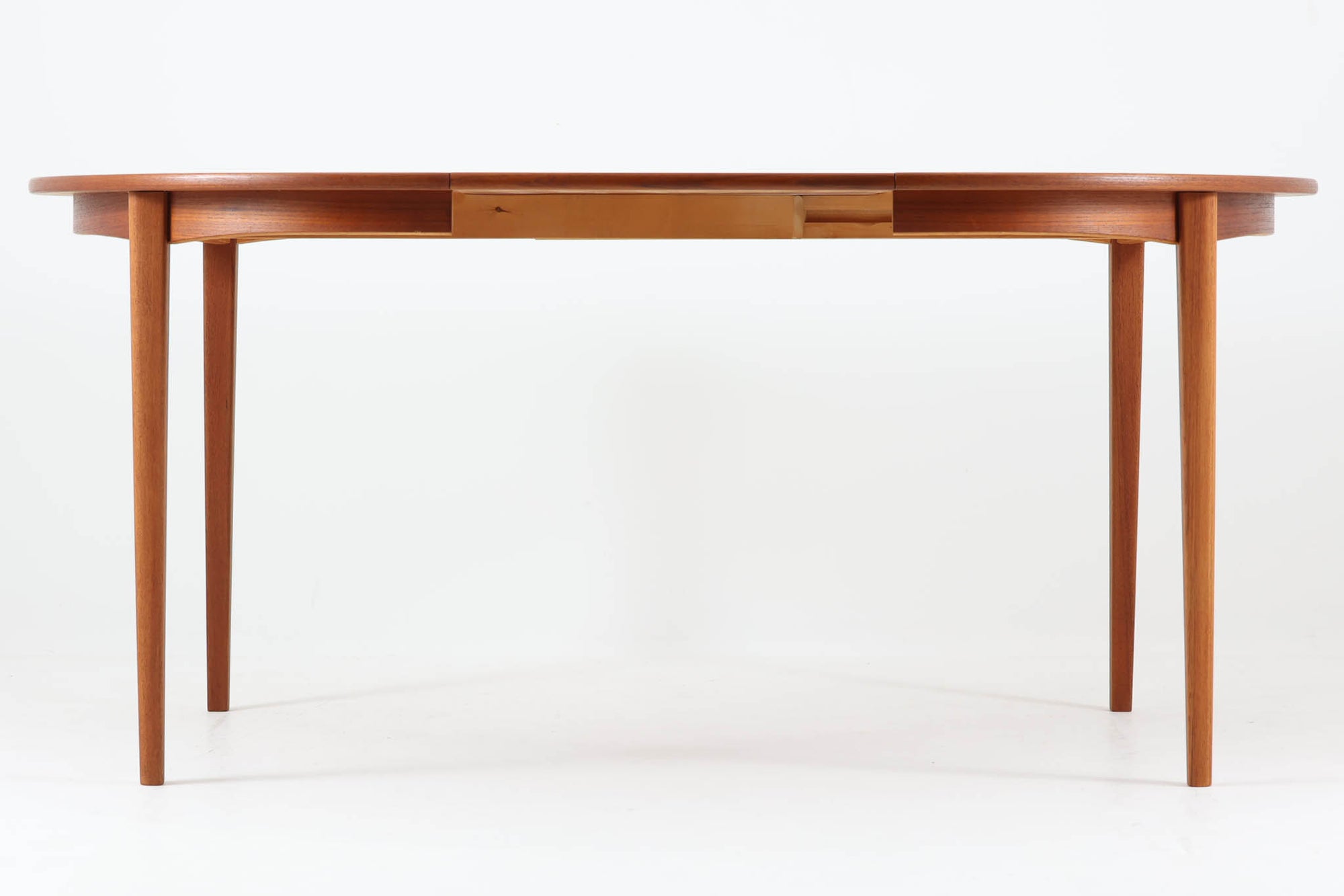 北欧デンマークより買い付けたビンテージの円形ダイニングテーブルです。美しいチーク材の木目が上品な印象で、北欧らしい温かみと洗練を兼ね備えたデザインです。天板は、幅112cmから162cmへと拡張が可能なエクステンションタイプとなっています。普段はコンパクトに、来客時には広々と使用できる実用性に優れた構造で、先細りの丸脚が軽やかな印象を与えます。シンプルながらも上質な造りで、空間にすっと溶け込む一台です。