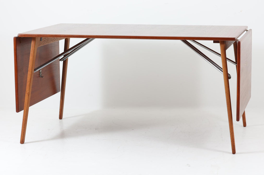 北欧から買い付けた、Børge mogensenデザインのmodel 162です。「DESIGN mUSEUm DANmARK」によれば、このモデルは1953年にデザインされたものです。Børge mogensenの作品としては珍しく、金属と木材を組み合わせたデザインが特徴です。天板には、色味の濃い高品質なチーク材が使用され、脚部はナチュラルな色合いのスリムなデザインが採用されています。また、補強材として使用されたスチールの色合いとの調和により、全体的に非常に洗練された印象を与えつつも、スチールにより高い強度が確保されています。天板中央のビスを外すことで、テーブルは折り畳み可能となり、引っ越し時の搬入や搬出も安心して行えます。