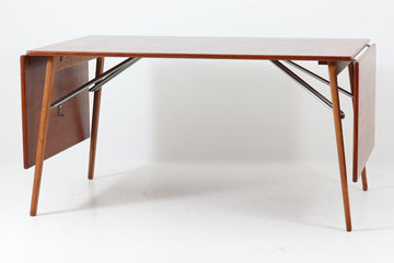 北欧から買い付けた、Børge mogensenデザインのmodel 162です。「DESIGN mUSEUm DANmARK」によれば、このモデルは1953年にデザインされたものです。Børge mogensenの作品としては珍しく、金属と木材を組み合わせたデザインが特徴です。天板には、色味の濃い高品質なチーク材が使用され、脚部はナチュラルな色合いのスリムなデザインが採用されています。また、補強材として使用されたスチールの色合いとの調和により、全体的に非常に洗練された印象を与えつつも、スチールにより高い強度が確保されています。天板中央のビスを外すことで、テーブルは折り畳み可能となり、引っ越し時の搬入や搬出も安心して行えます。