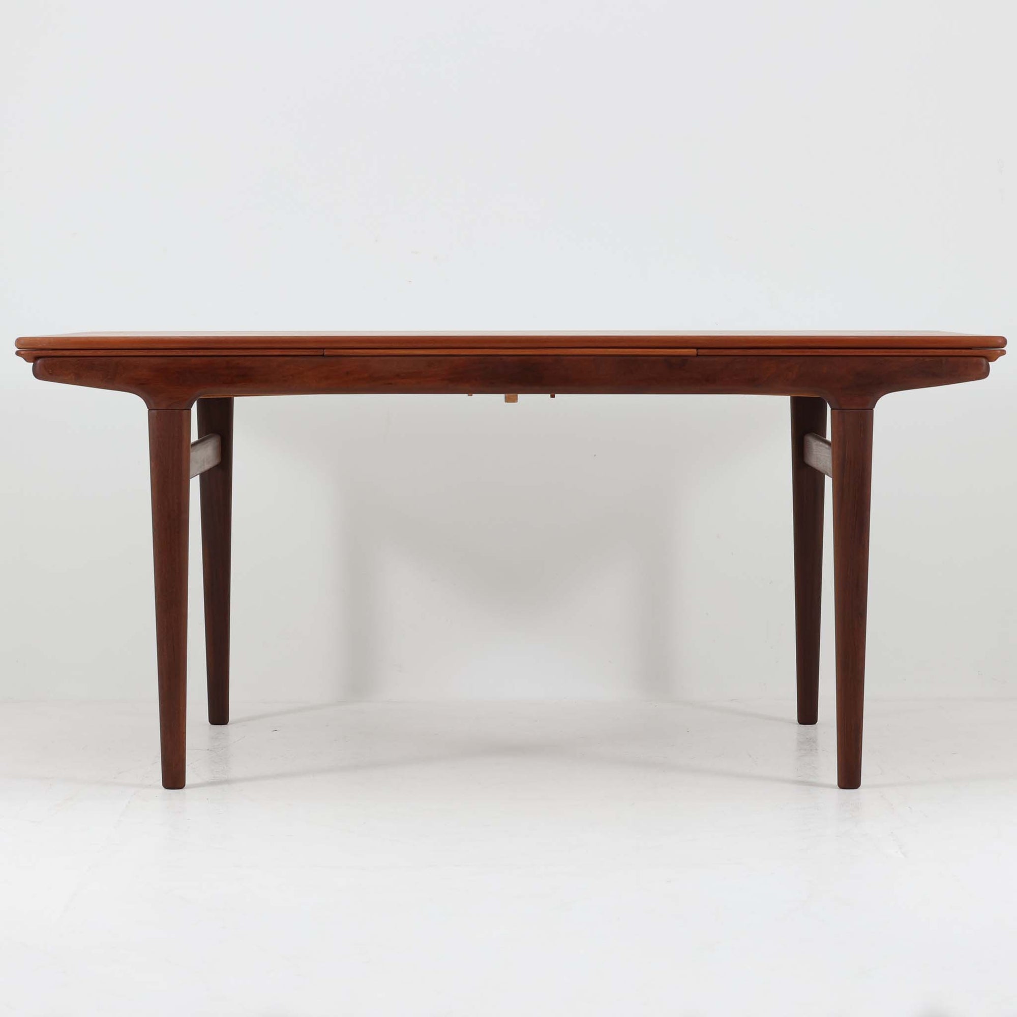 Johannes Andersenデザイン、Uldum Mobelfabrik社製のエクステンションダイニングテーブルです。チーク材特有の温かみある色調と繊細な木目が美しく、北欧家具らしい洗練された雰囲気を漂わせます。幅160cmから最大261cmまで拡張可能で、来客時や家族の集まりなどに柔軟に対応できる実用性の高さも魅力です。丸みを帯びたエッジや脚部の優雅な曲線など、アンダーセンならではの造形美が感じられる逸品で、ビンテージならではの風格と存在感を備えています。