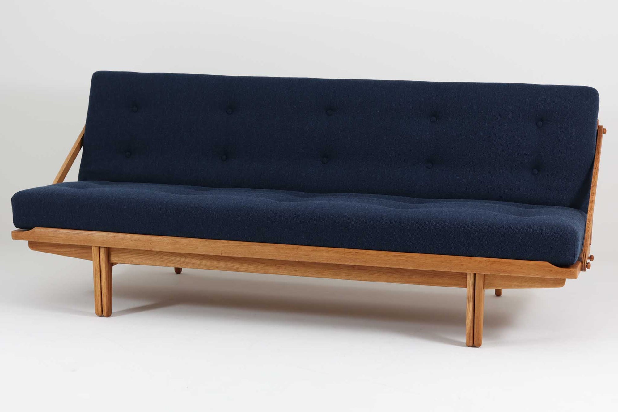 Poul m. Voltherによるデイベッドは、機能的で美しいデザインが特徴のビンテージ家具です。ソファとしての使用だけでなく、背もたれを倒すとリラックスできるベッドとしても使用できるため、用途に応じて柔軟に使えます。良質なオーク材が使用されたフレームとスラット構造が安定感を与え、クッション内部にはスプリングが内包されており、快適な座り心地と寝心地を提供してくれます。