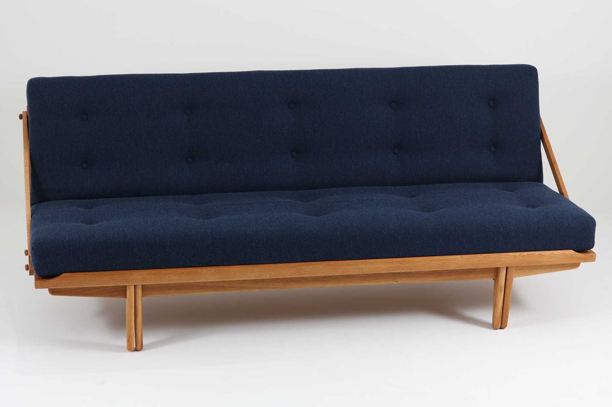 Poul m. Voltherによるデイベッドは、機能的で美しいデザインが特徴のビンテージ家具です。ソファとしての使用だけでなく、背もたれを倒すとリラックスできるベッドとしても使用できるため、用途に応じて柔軟に使えます。良質なオーク材が使用されたフレームとスラット構造が安定感を与え、クッション内部にはスプリングが内包されており、快適な座り心地と寝心地を提供してくれます。