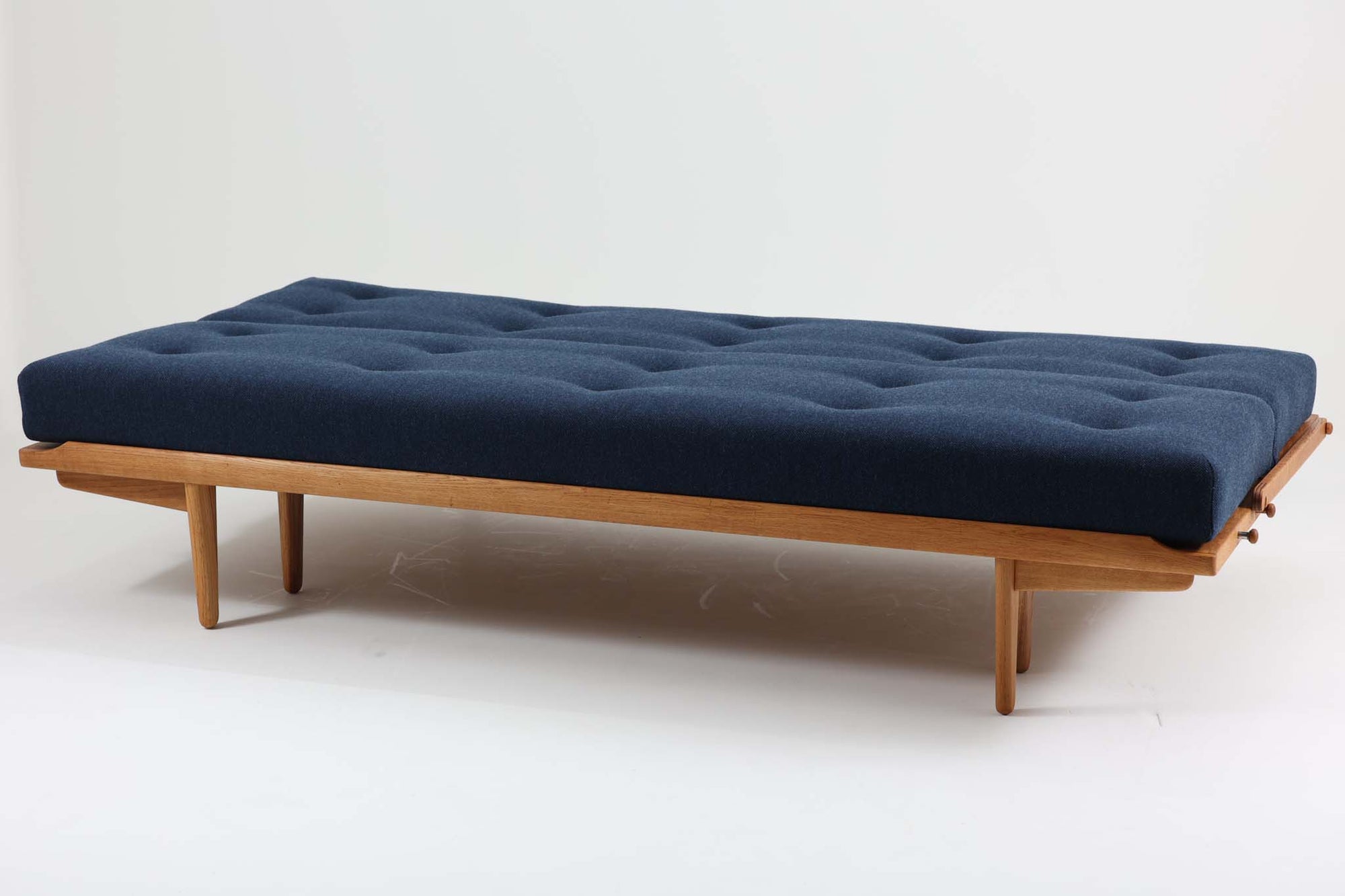 Poul m. Voltherによるデイベッドは、機能的で美しいデザインが特徴のビンテージ家具です。ソファとしての使用だけでなく、背もたれを倒すとリラックスできるベッドとしても使用できるため、用途に応じて柔軟に使えます。良質なオーク材が使用されたフレームとスラット構造が安定感を与え、クッション内部にはスプリングが内包されており、快適な座り心地と寝心地を提供してくれます。