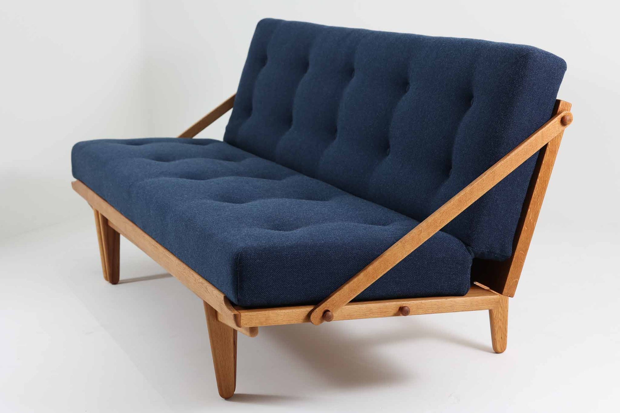 Poul m. Voltherによるデイベッドは、機能的で美しいデザインが特徴のビンテージ家具です。ソファとしての使用だけでなく、背もたれを倒すとリラックスできるベッドとしても使用できるため、用途に応じて柔軟に使えます。良質なオーク材が使用されたフレームとスラット構造が安定感を与え、クッション内部にはスプリングが内包されており、快適な座り心地と寝心地を提供してくれます。