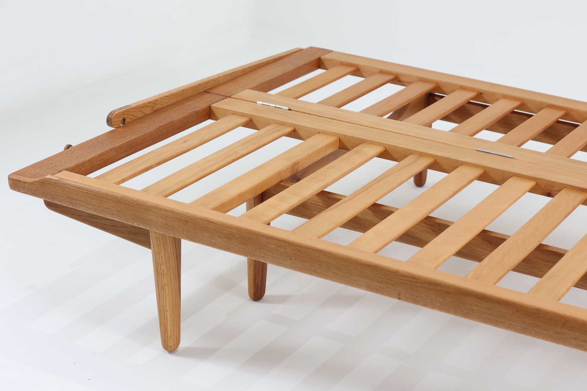 Poul m. Voltherによるデイベッドは、機能的で美しいデザインが特徴のビンテージ家具です。ソファとしての使用だけでなく、背もたれを倒すとリラックスできるベッドとしても使用できるため、用途に応じて柔軟に使えます。良質なオーク材が使用されたフレームとスラット構造が安定感を与え、クッション内部にはスプリングが内包されており、快適な座り心地と寝心地を提供してくれます。