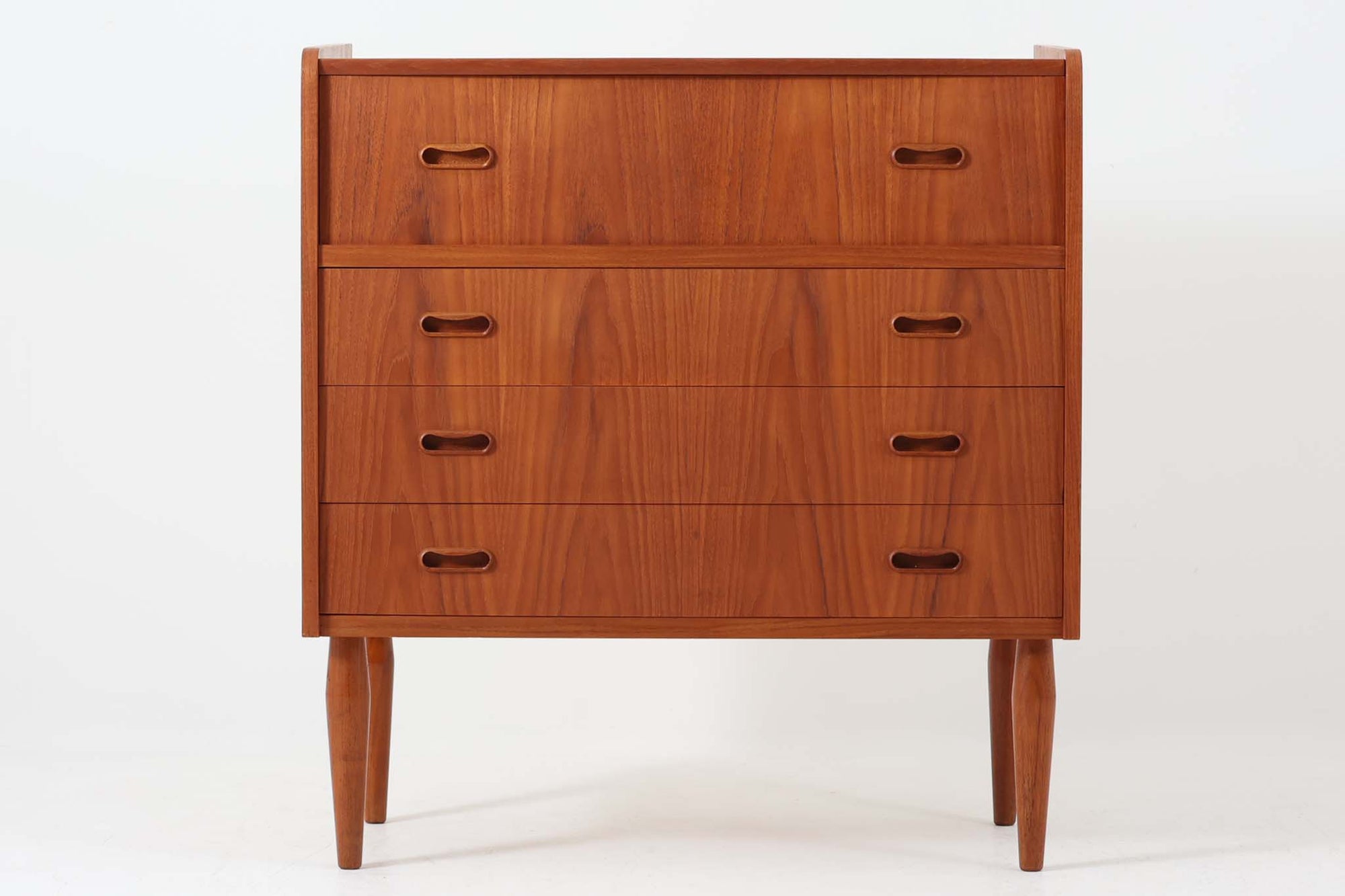 温かみのあるチーク材を贅沢に使用したデンマーク製のチェストドレッサーです。上段の天板を開けるとミラーが現れ、内部には小物収納に便利な引き出しと仕切り棚が備えられており、機能性に優れています。下部には3段の引き出しが配置され、衣類や日用品の収納にも対応。丸みを帯びた脚部や、手掛かりの滑らかな曲線が北欧ビンテージ家具ならではの優美なディテールを際立たせています。寝室やリビングでの収納兼用ドレッサーとしておすすめの一台です。