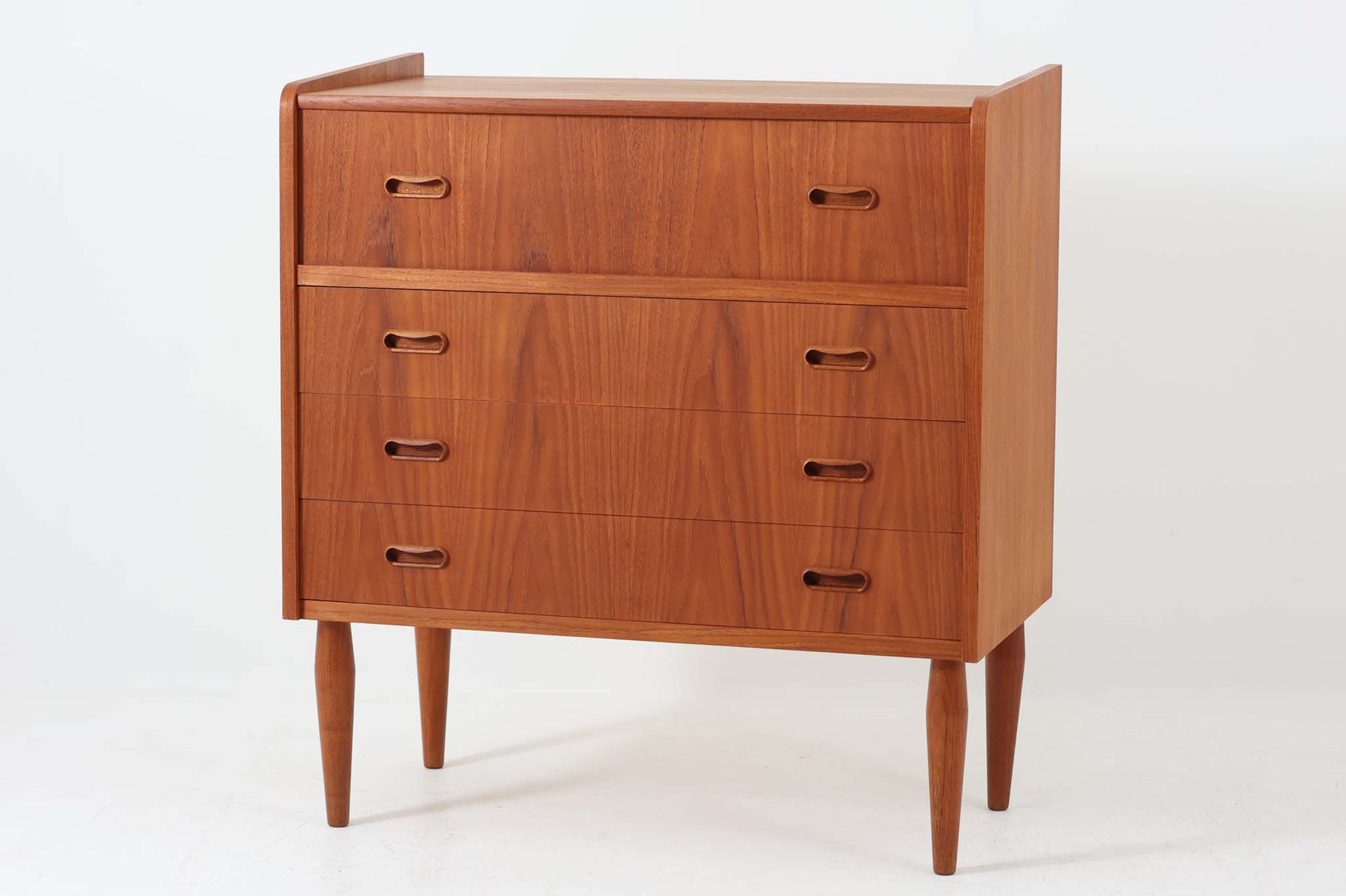 温かみのあるチーク材を贅沢に使用したデンマーク製のチェストドレッサーです。上段の天板を開けるとミラーが現れ、内部には小物収納に便利な引き出しと仕切り棚が備えられており、機能性に優れています。下部には3段の引き出しが配置され、衣類や日用品の収納にも対応。丸みを帯びた脚部や、手掛かりの滑らかな曲線が北欧ビンテージ家具ならではの優美なディテールを際立たせています。寝室やリビングでの収納兼用ドレッサーとしておすすめの一台です。