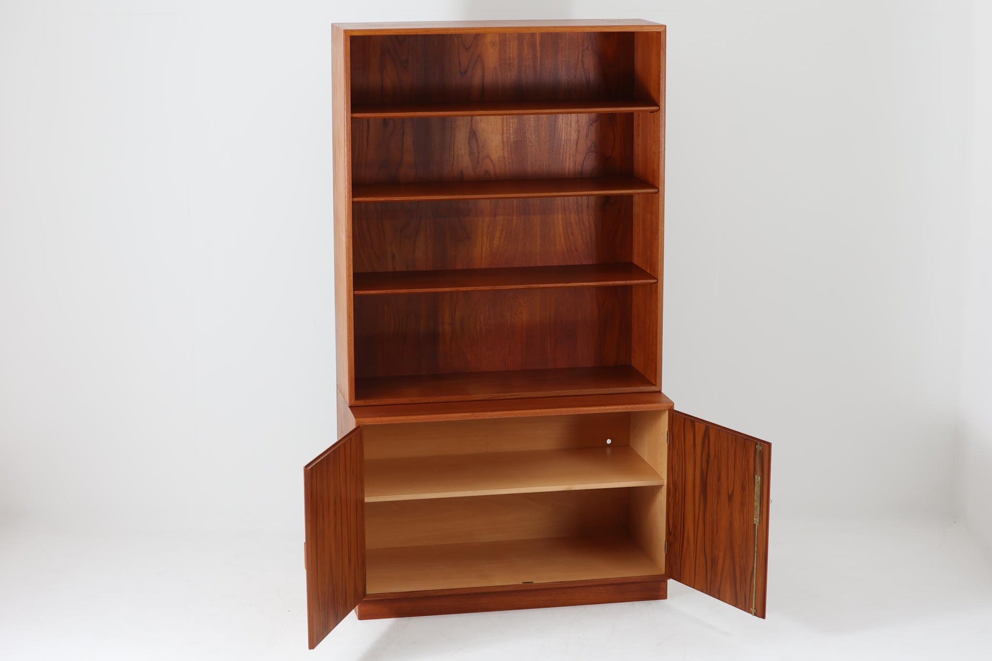 デンマークの巨匠ボーエ・モーエンセンがデザインした、Soborg mobler社製のビンテージディスプレイシェルフ。1950～70年代に製造された北欧家具の名作です。チーク材の美しい木目が際立ち、温かみのある風合いが魅力。上部はオープンシェルフ、下部には収納キャビネットを備え、実用性にも優れています。可動棚により、収納スペースを自由に調整可能。モーエンセンらしいシンプルな掘り込み取っ手が施された洗練されたデザイン。ビンテージならではの風合いを楽しめる、北欧家具の逸品です。