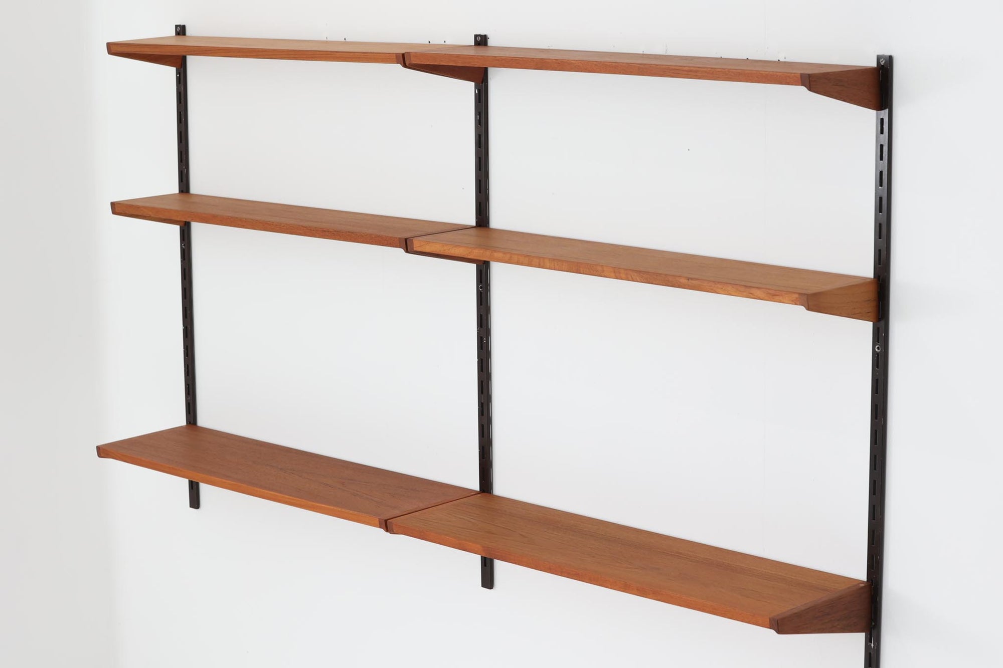 このウォールシェルフは、デンマークの有名デザイナー、カイ・クリスチャンセンがデザインしたもので、Fm furnitureから発売されました。フレームを壁面に取り付け、棚板を好きな位置に配置する事が出来ます。写真の様に2列で使用する以外にも、1列で使用する事も可能です。