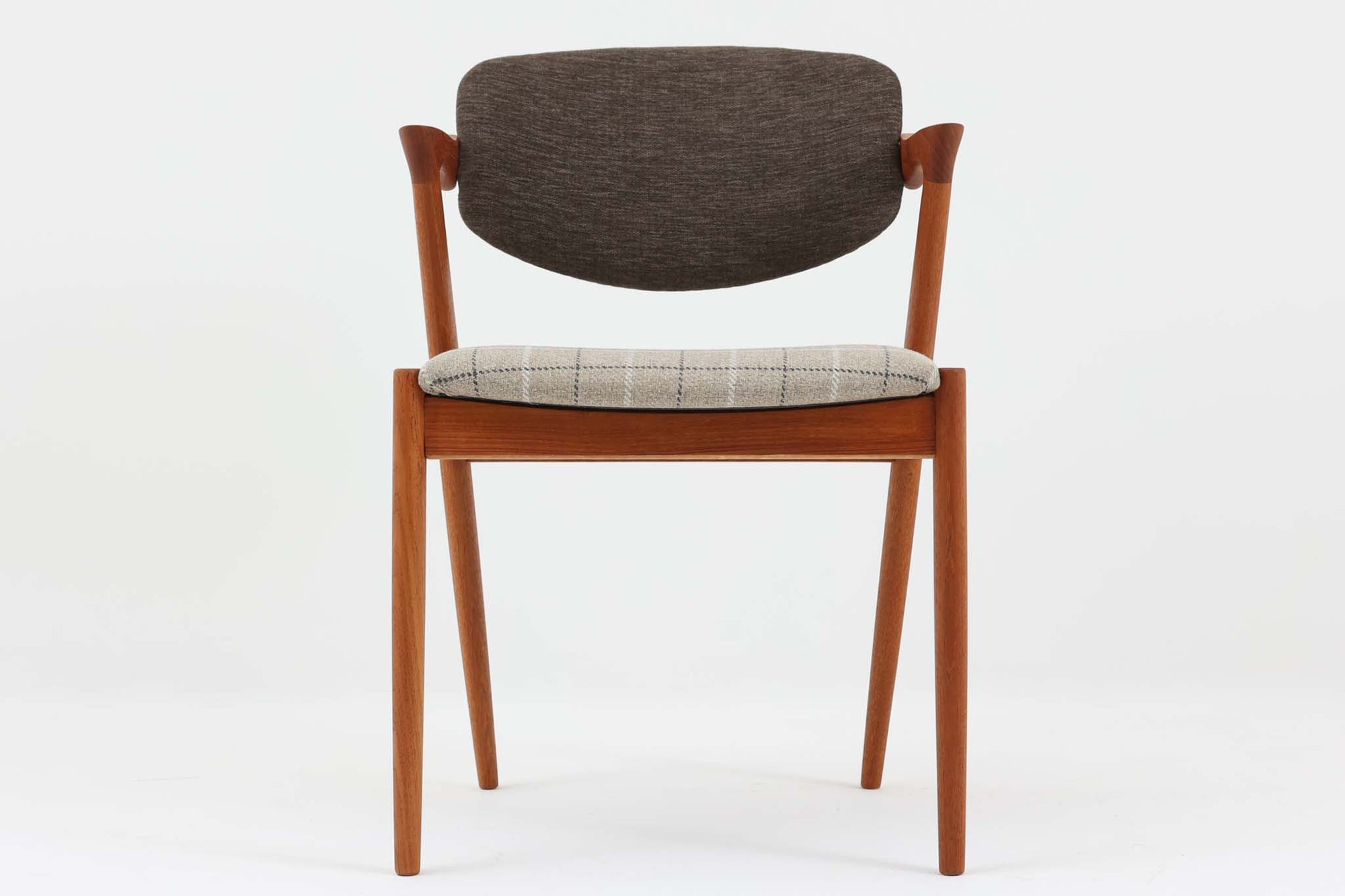 こちらはカイ・クリスチャンセンによる「No42チェア」で、温かみのあるチーク材を使用したシンプルでエレガントなデザインが特徴です。流れるような曲線と美しい背もたれが座り心地を向上させ、長時間でも快適に使用できます。チーク材の質感と色合いが、どんなインテリアにも調和し、ダイニングや作業用椅子としても活躍する一品です。チーク材のモデルは復刻されていないため、ビンテージ家具としてのみ入手可能です。