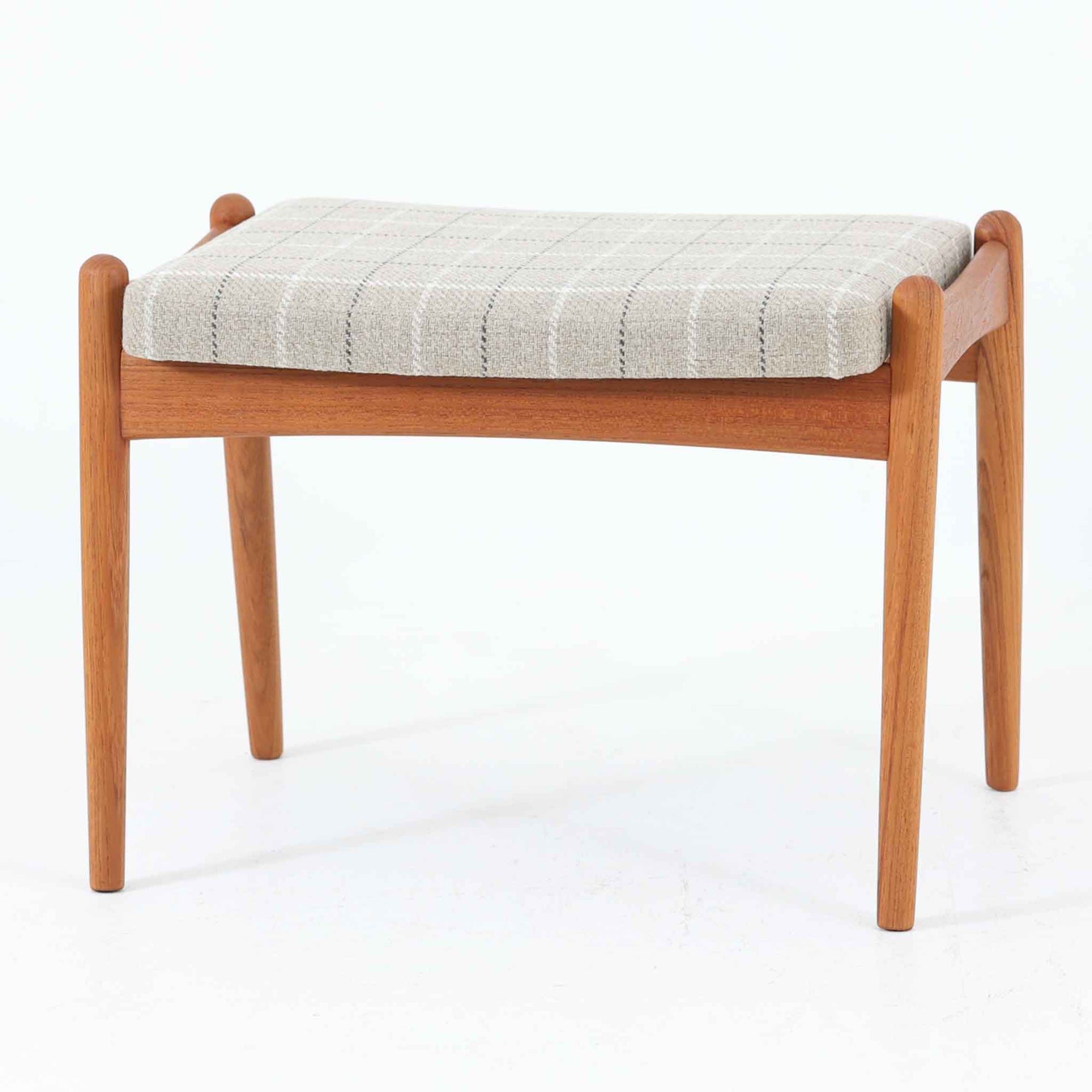 北欧デンマーク製のこちらのスツールは、チーク材のフレームにチェック柄のファブリックを組み合わせた温かみのある佇まいが魅力です。座面裏にある金具により角度調整が可能な珍しい仕様で、オットマンとしてだけでなく、ちょっとした腰掛けや足置きとしても柔軟に活躍します。コンパクトながらも曲線を活かしたデザインと堅牢な造りが、ビンテージらしい味わいと使い勝手の良さを兼ね備えています。
