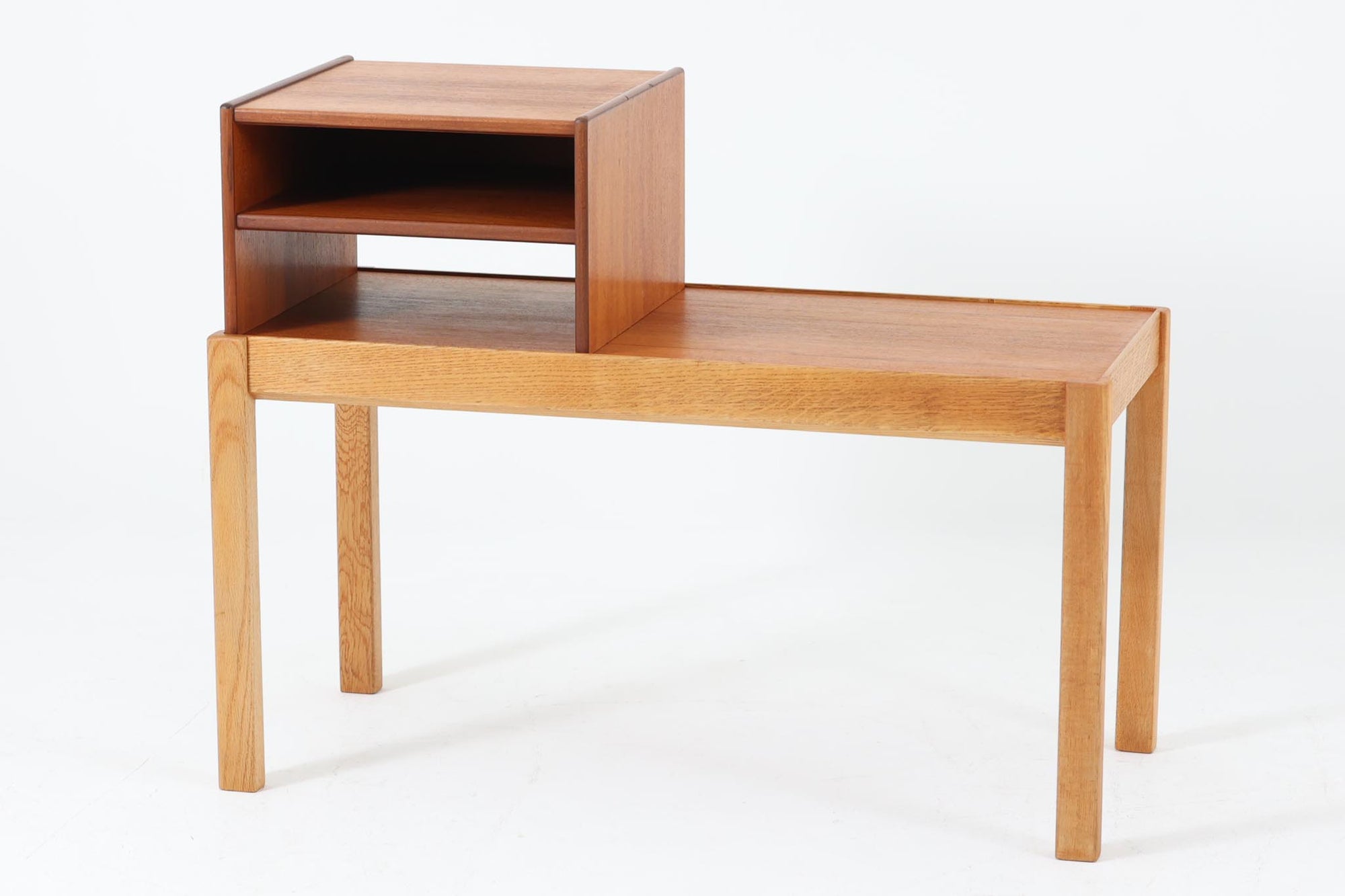 北欧より買い付けたサイドテーブルです。上部の収納ボックスはチーク材製で、取り外し可能な仕様。内部には便利な棚が備えられており、機能性も良好です。テーブル部分にはオーク材が使用され、頑丈な4本脚が安定感のある佇まいを演出してくれます。電話台としてはもちろん、玄関やリビングのサイドテーブルとしても活躍する、汎用性の高い一台です。異なる木目と色合いが生み出すコントラストが、北欧デザインならではの温かみを感じさせてくれます。