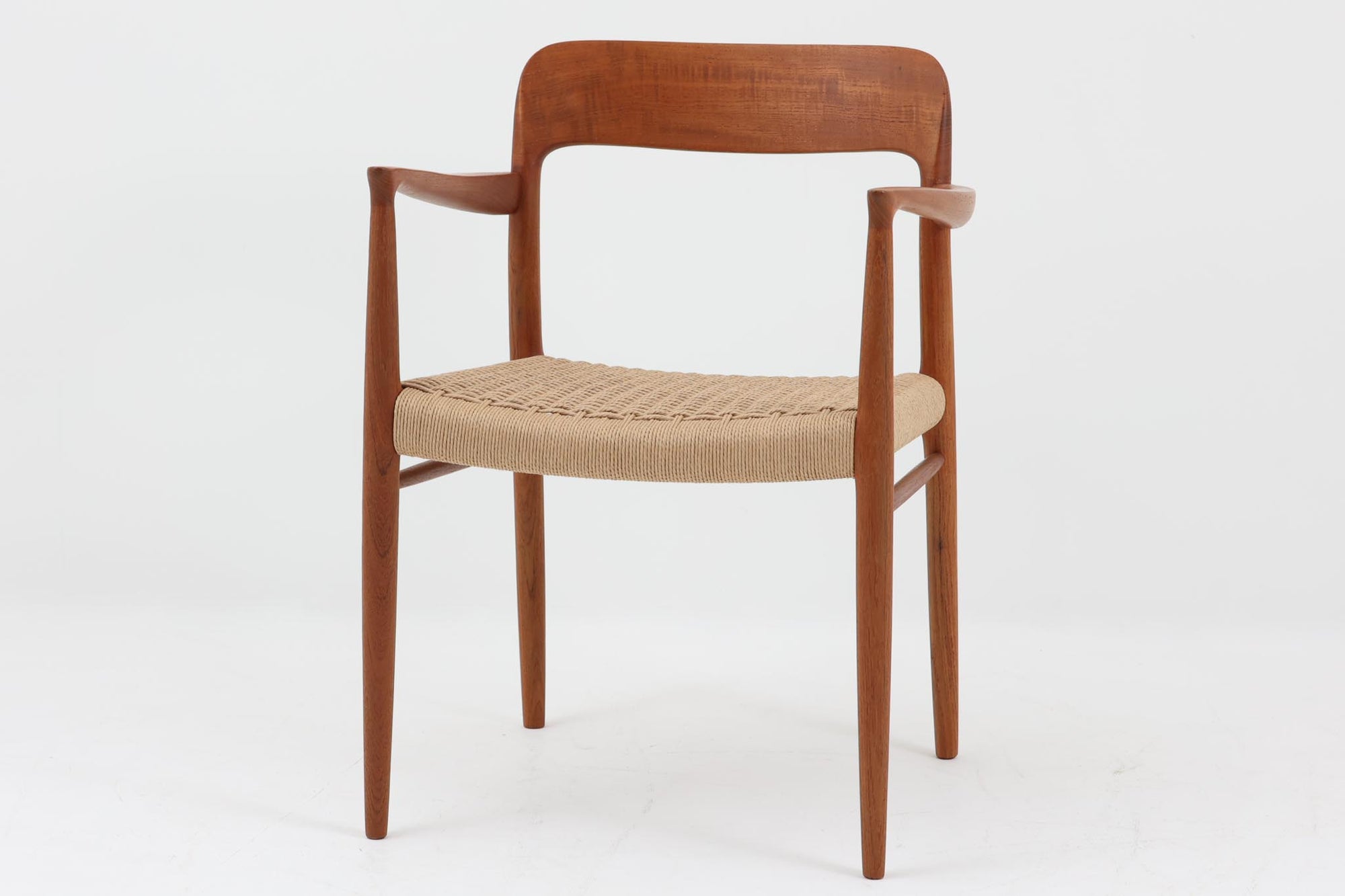北欧より買い付けたJ.L. moller社製のmodel 56アームチェアです。良質なチーク材が使用されており、厚みのあるチーク材が熟練の職人によって削り出されており、軽快な印象を受けます。座面にはペーパーコードが使用されており、自然で耐久性のある素材が特徴です。こちらのチェアはペーパーコードを張り替え済みのため、清潔で快適な状態でご使用いただけます。また、長く使用して座面が弱ってきた場合でも、張替えが可能なため、適切なメンテナンスを施すことで世代を超えてお使いいただける点も魅力です。現行品の販売もございますが、チーク材のフレームはビンテージ品でのみ入手可能であり、現在では希少な作品となっています。