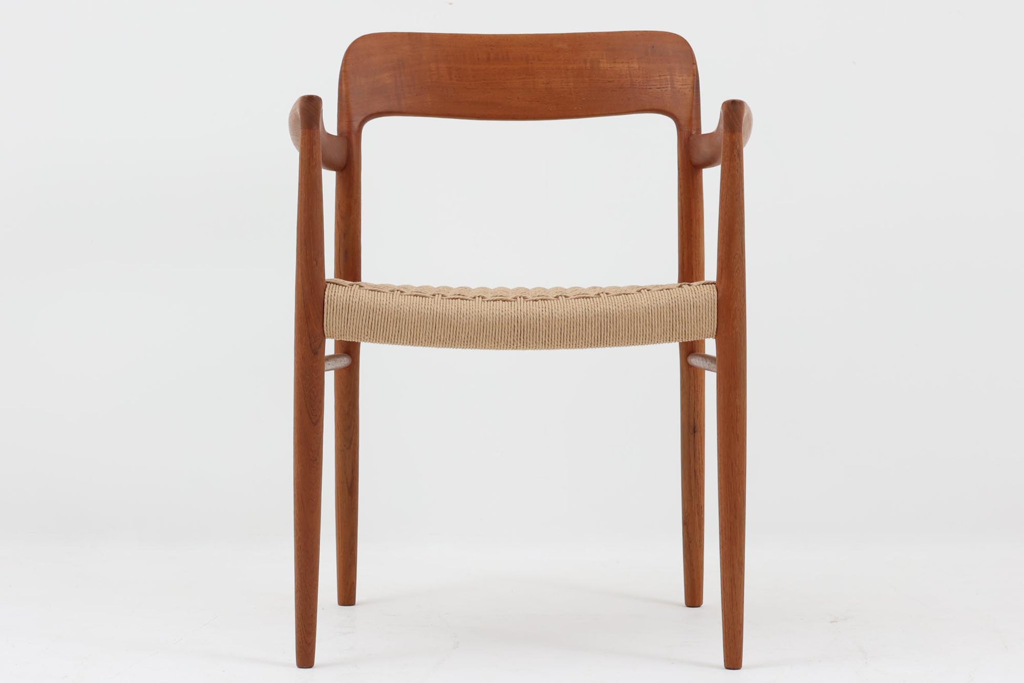 北欧より買い付けたJ.L. moller社製のmodel 56アームチェアです。良質なチーク材が使用されており、厚みのあるチーク材が熟練の職人によって削り出されており、軽快な印象を受けます。座面にはペーパーコードが使用されており、自然で耐久性のある素材が特徴です。こちらのチェアはペーパーコードを張り替え済みのため、清潔で快適な状態でご使用いただけます。また、長く使用して座面が弱ってきた場合でも、張替えが可能なため、適切なメンテナンスを施すことで世代を超えてお使いいただける点も魅力です。現行品の販売もございますが、チーク材のフレームはビンテージ品でのみ入手可能であり、現在では希少な作品となっています。